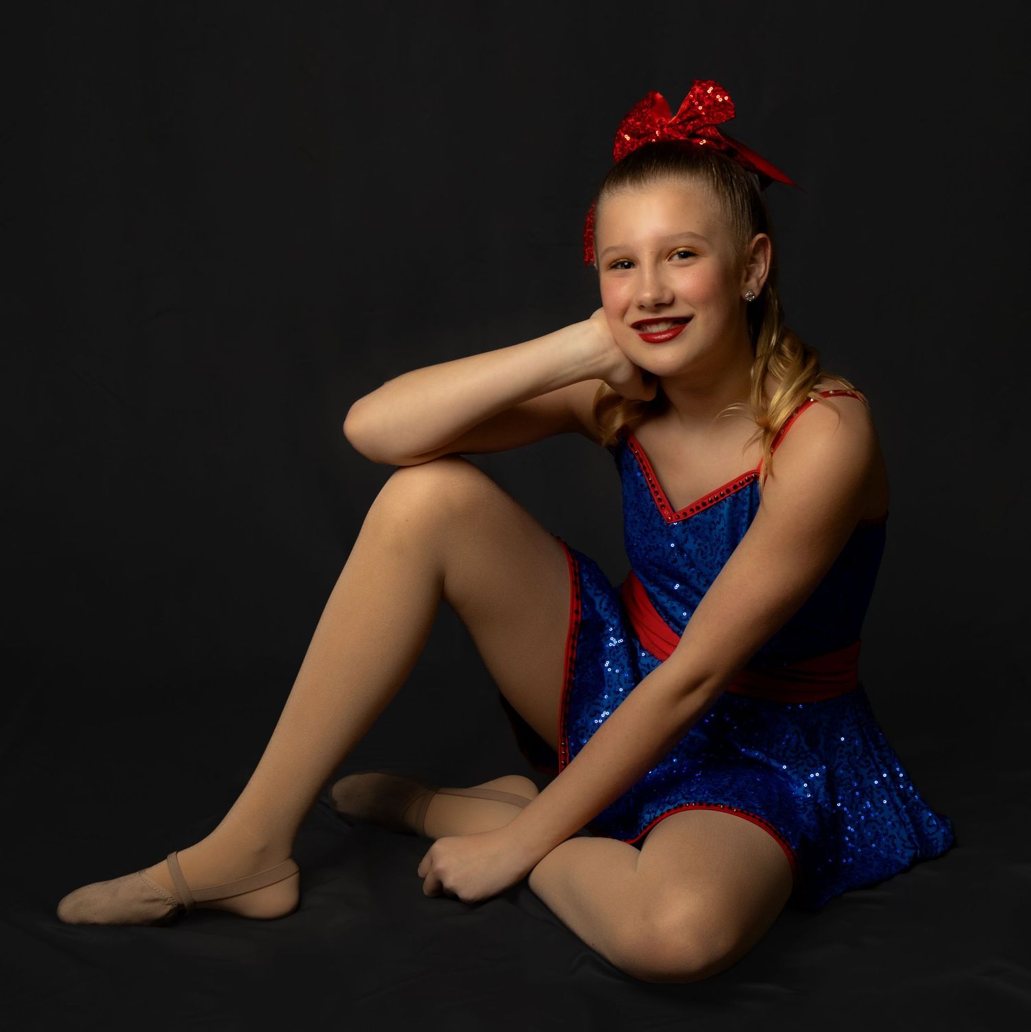 Dancer in blue sparkly costume striking graceful seated poses against dark background in photo series.