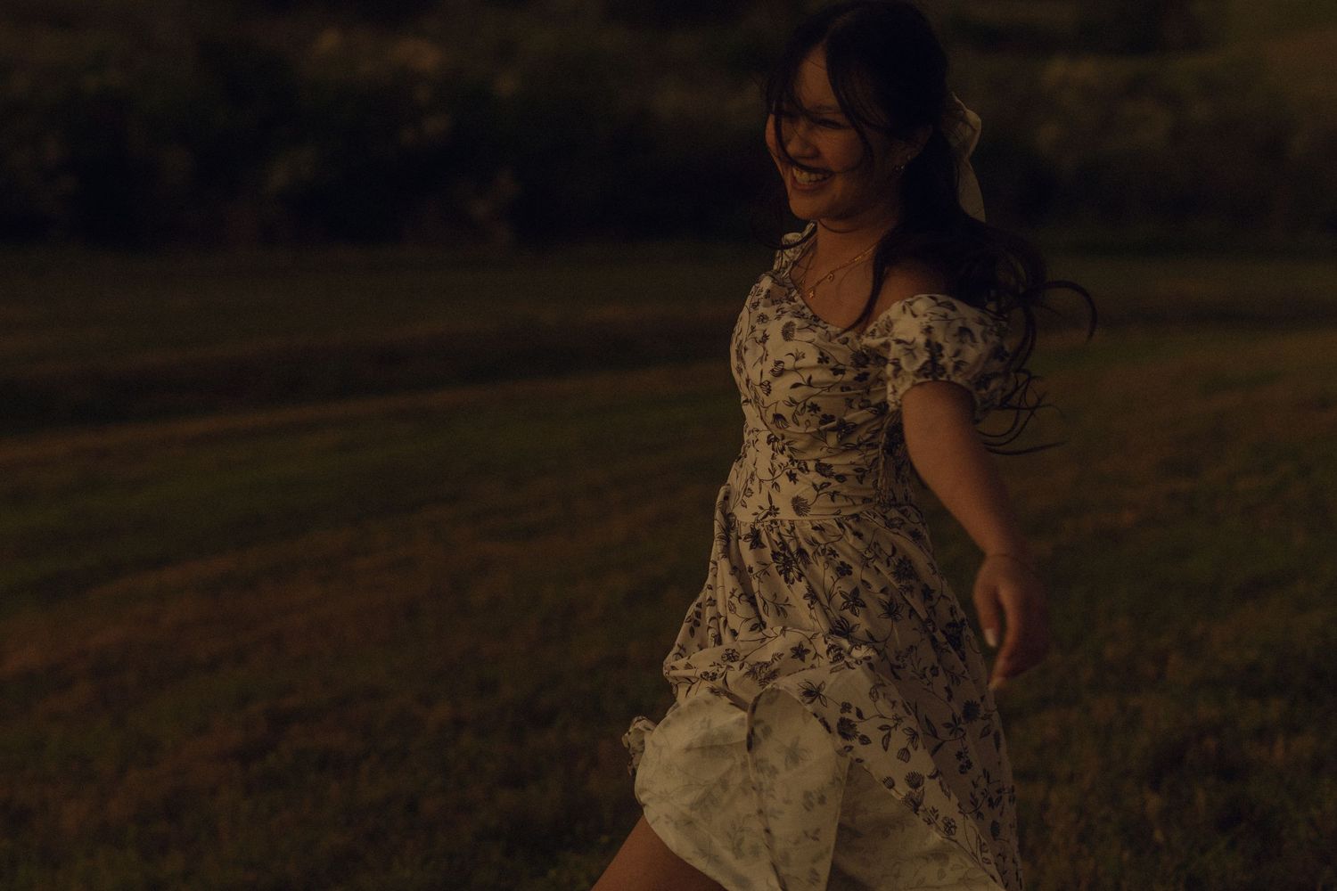 f in the field - standing at an angle- smiling - dress flowing