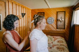 Person getting ready for special event in cozy wood-paneled room with vintage decor and warm lighting.