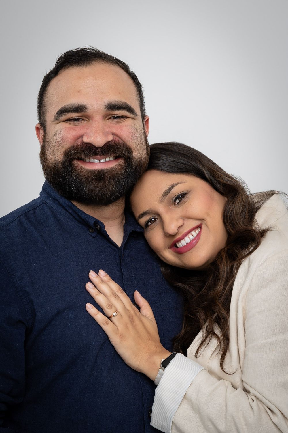 Sweet couple photos showing intimacy with navy and cream colored outfits in studio setting.