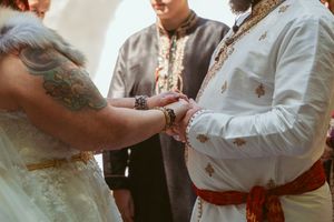 Several photos showing rings being exchanged during a rustic outdoor wedding ceremony with white attire.