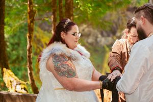 A medieval-themed wedding ceremony taking place in a forest setting with a couple exchanging vows.