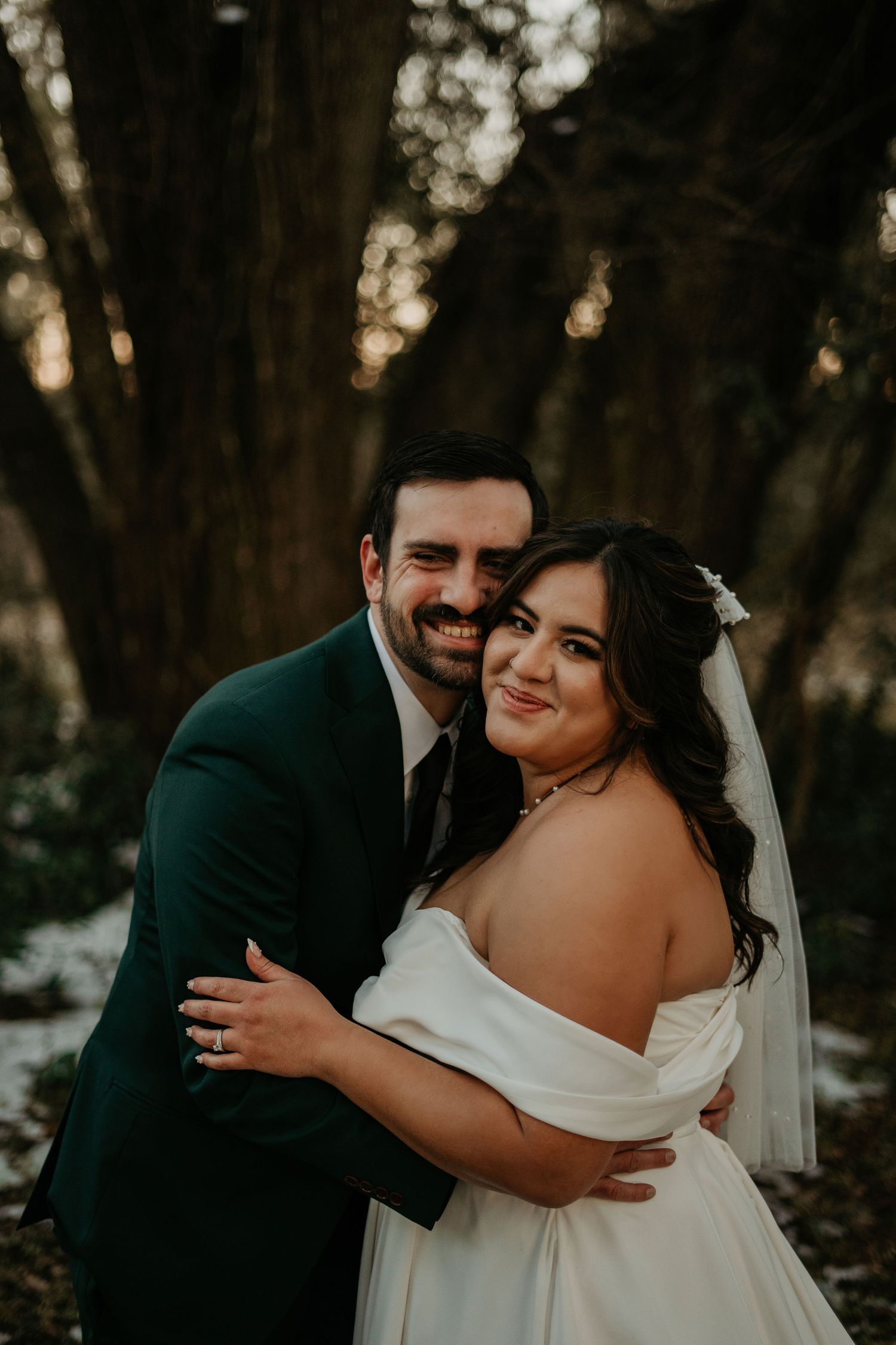 A tender wedding moment captured as couple shares a kiss while wearing delicate floral crowns in soft natural lighting.