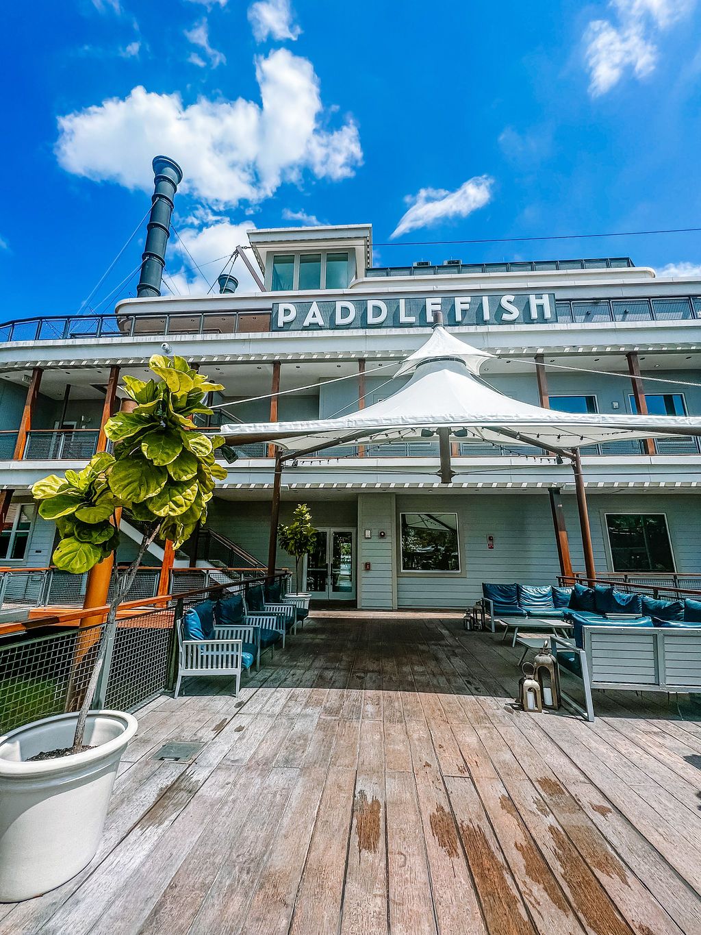 Exterior view of Paddlefish restaurant with white facade and outdoor deck seating area.