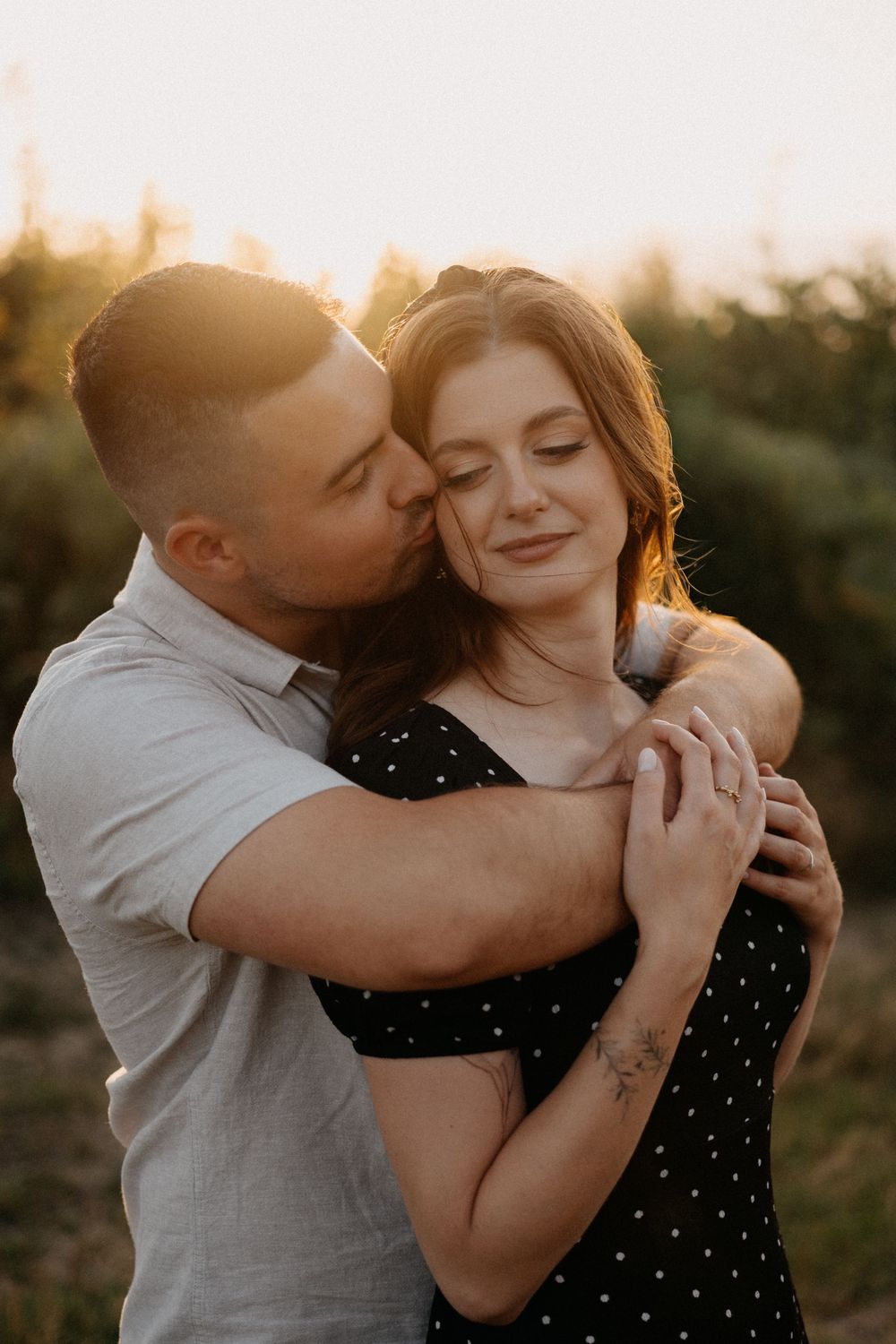 Intimate sunset portrait of a couple sharing tender moments outdoors.