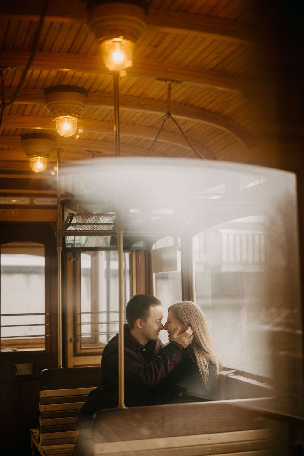 Intimate moment captured inside vintage train car with soft window light.