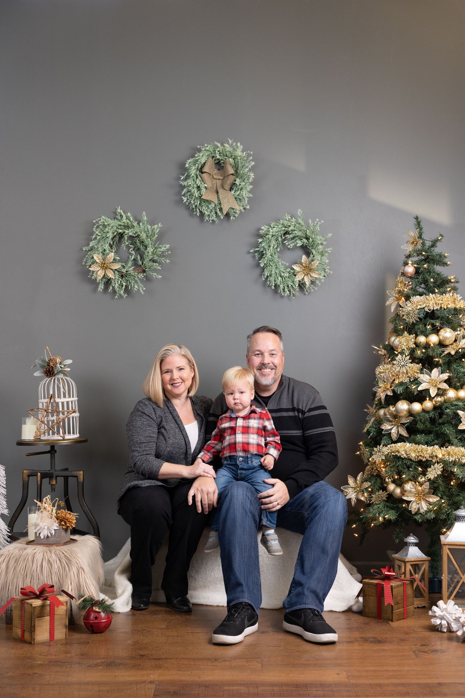 A series of holiday family portraits with a Christmas tree, decorative wreaths, and wrapped presents in the background.