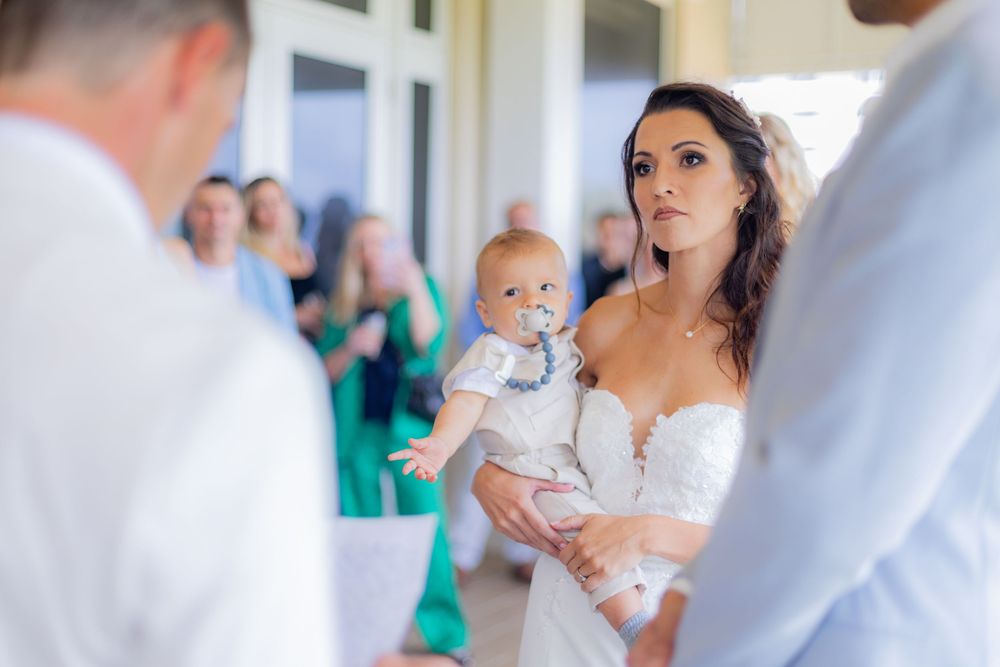 Bride holding her baby during ceremony in Palm Beach Shores Florida