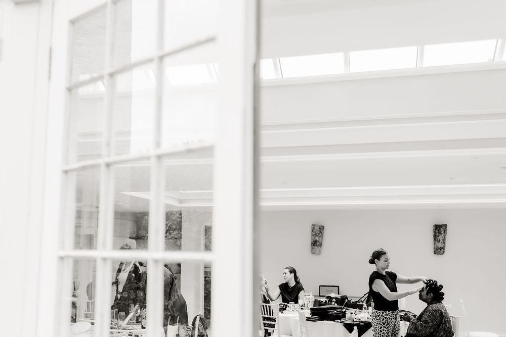 Black and white photo of people working in a bright office space with large windows and natural light.