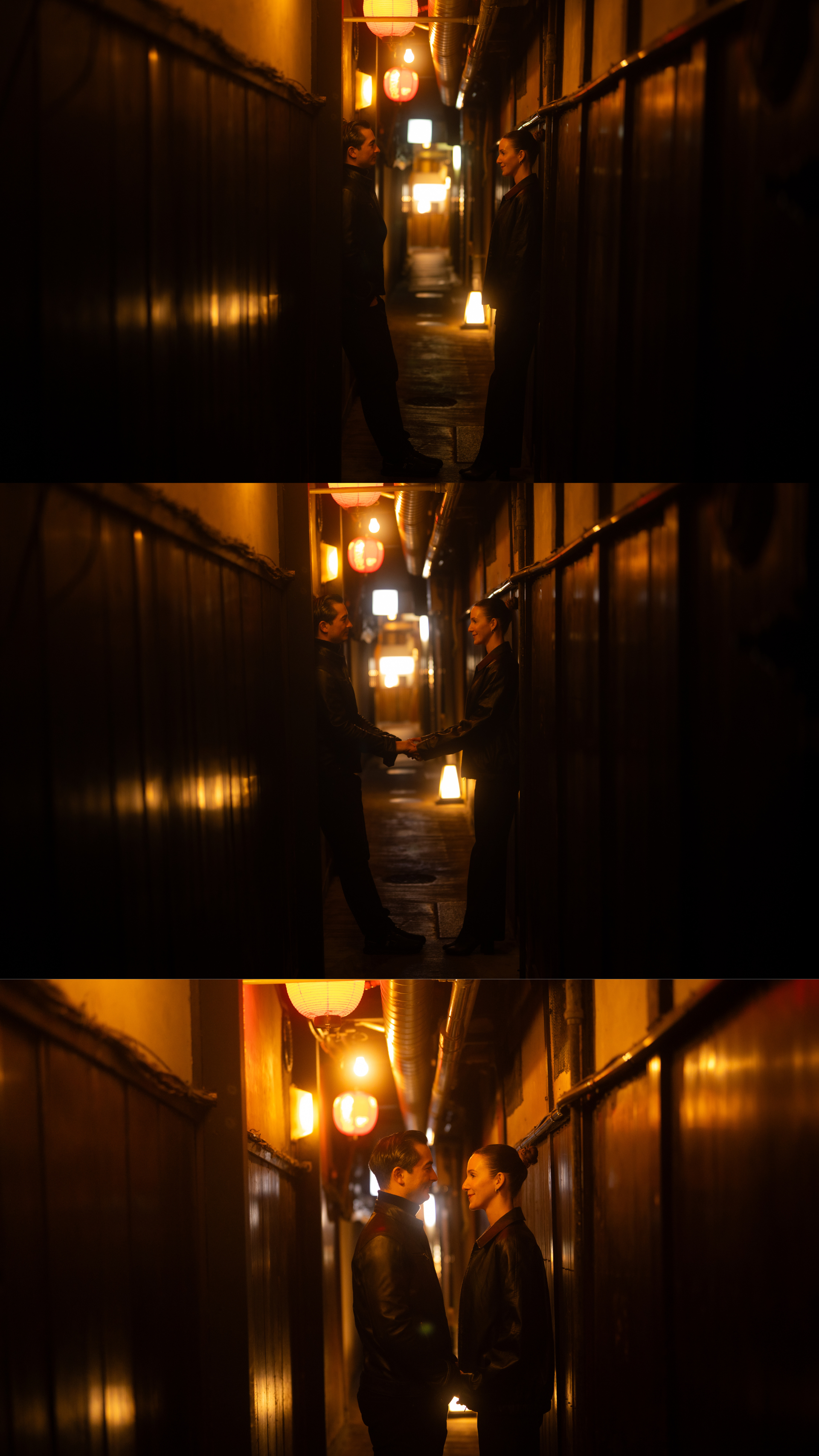 Couple sharing an intimate moment in a narrow dimly lit Japanese alleyway with warm lanterns.