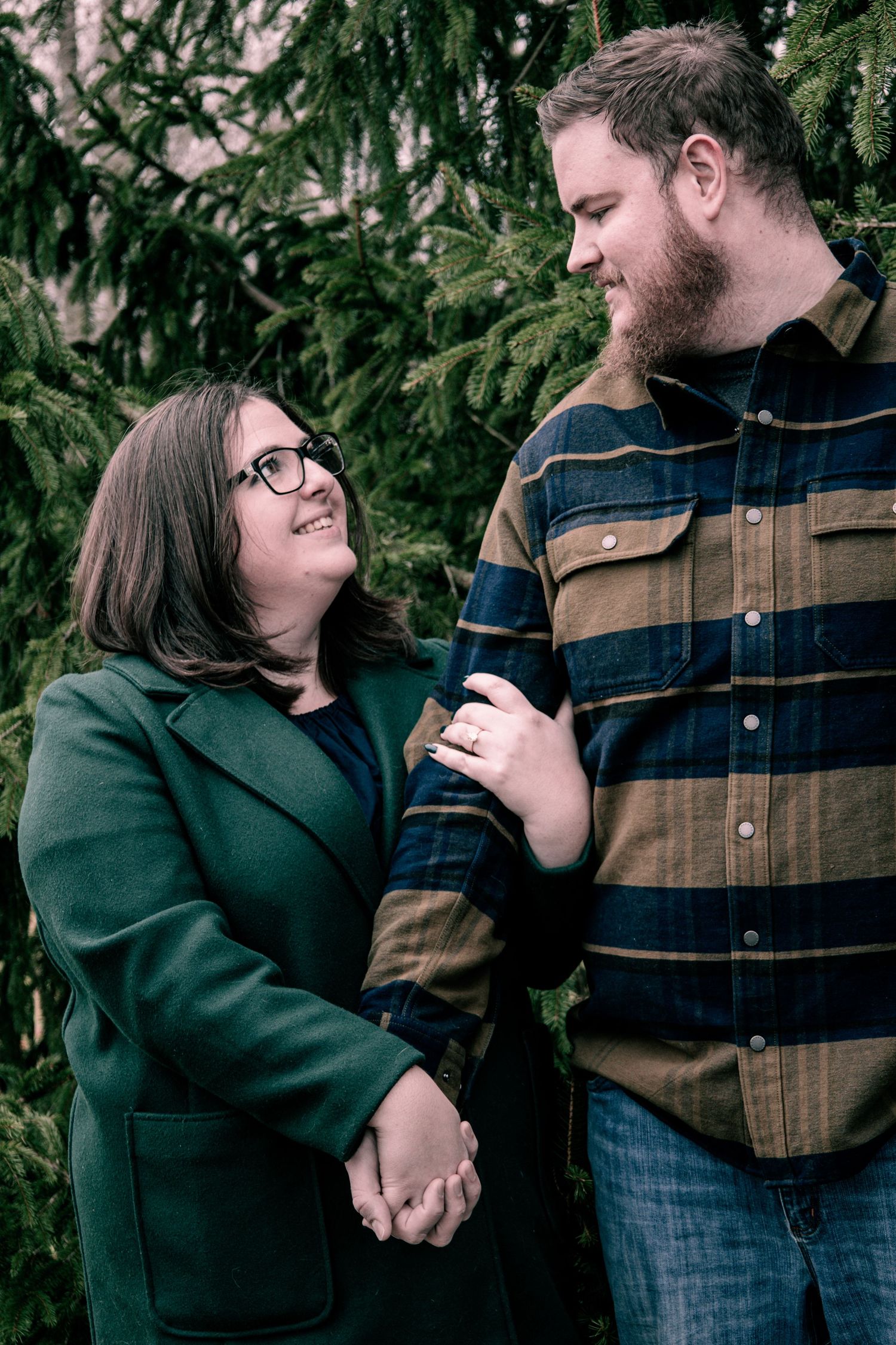 A couple shares tender moments in a series of progressive shots against an evergreen tree backdrop.