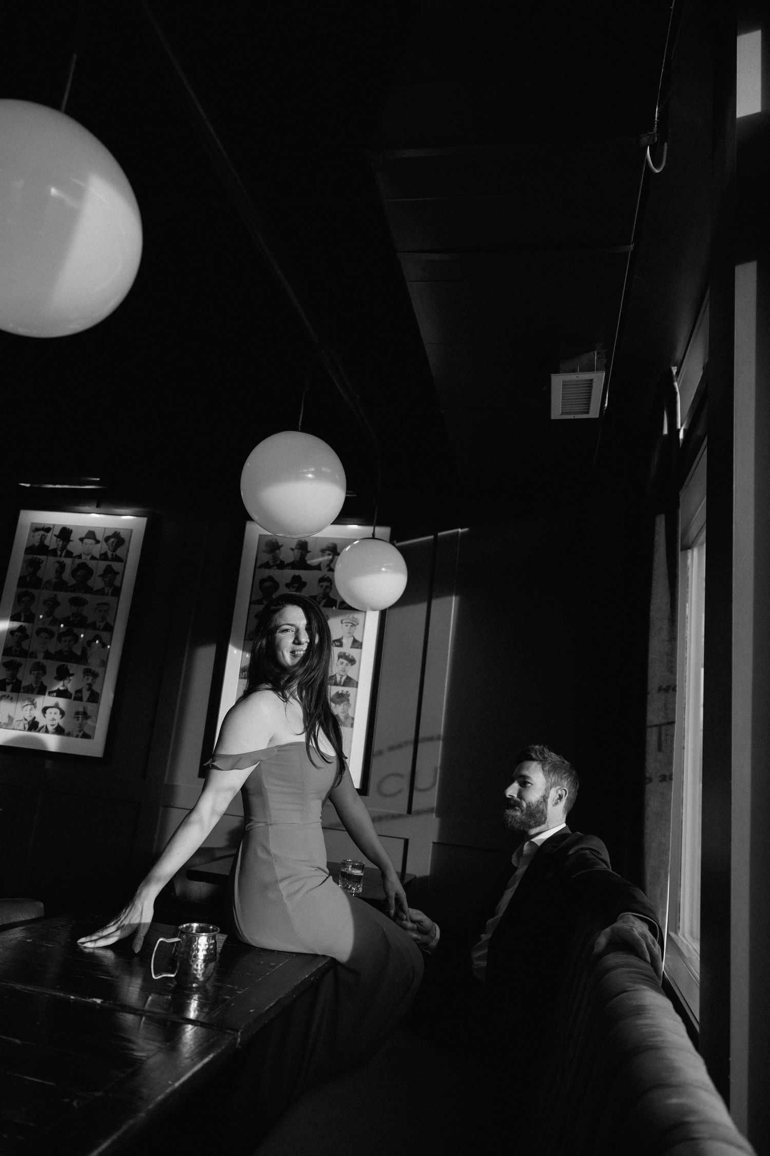A sequence of black and white photos shows someone playfully bouncing a white balloon in a dimly lit room.
