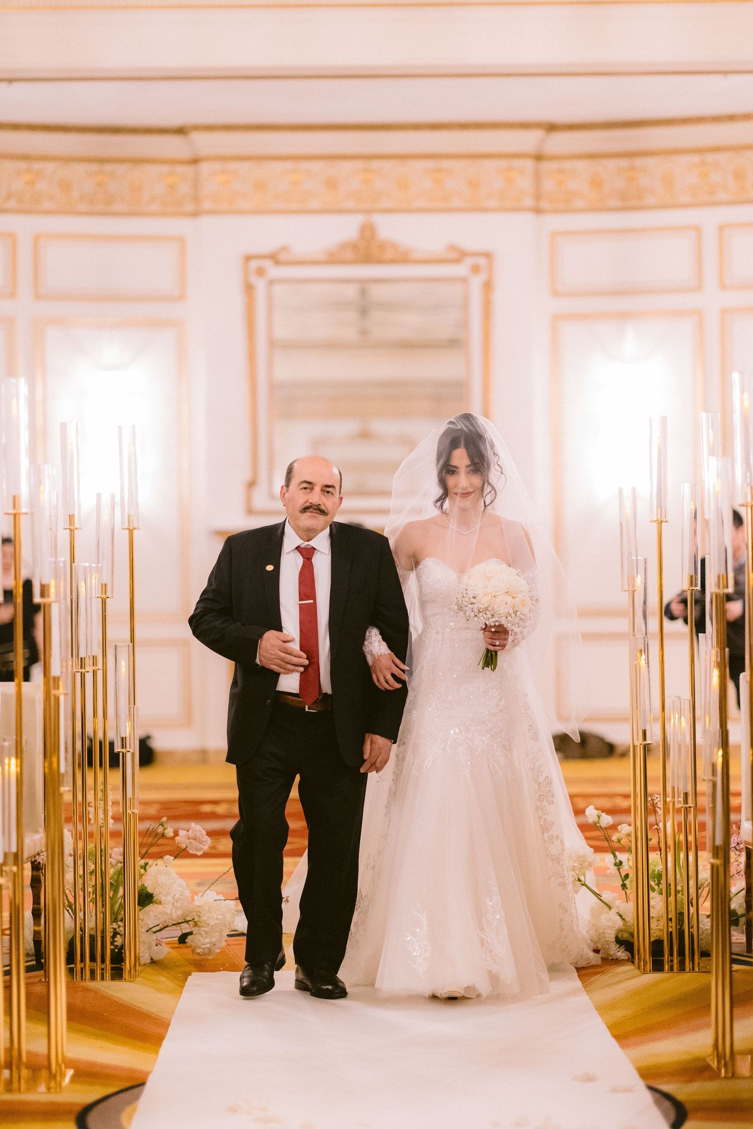 A panoramic view of an elegant ballroom with ornate gold details, mirrored walls, and crystal chandeliers.