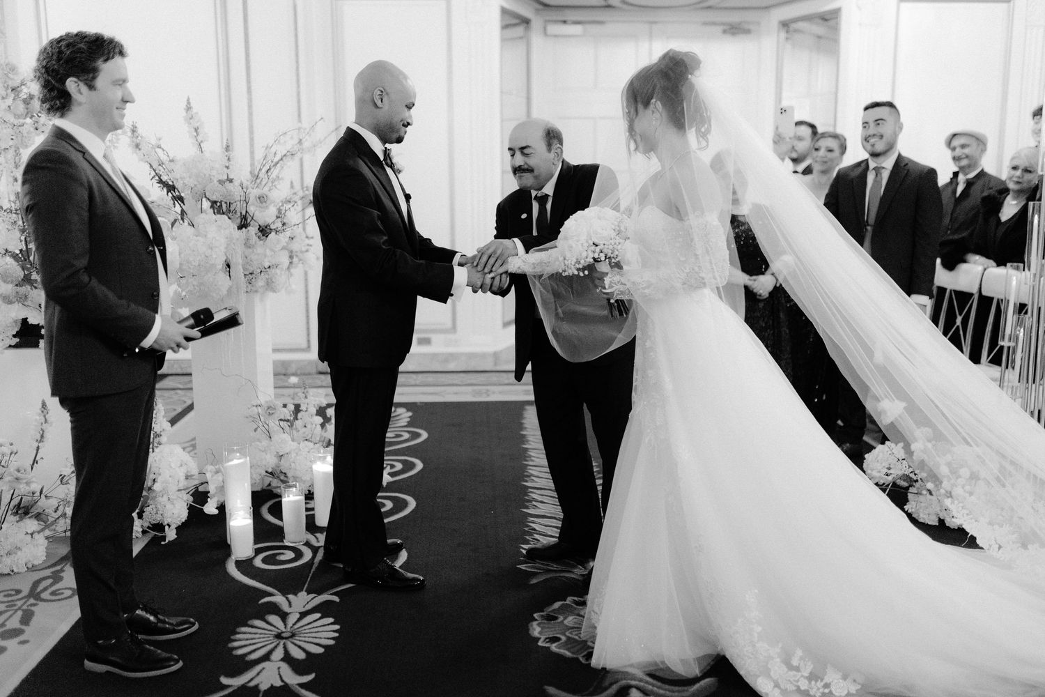 A wedding party dances together in a line at a reception venue during a celebration.