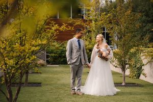 A couple shares a romantic moment outdoors surrounded by golden autumn foliage.