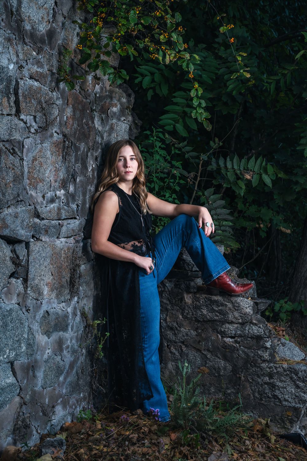 Artistic portrait series against a rustic stone wall surrounded by autumn foliage and natural lighting.