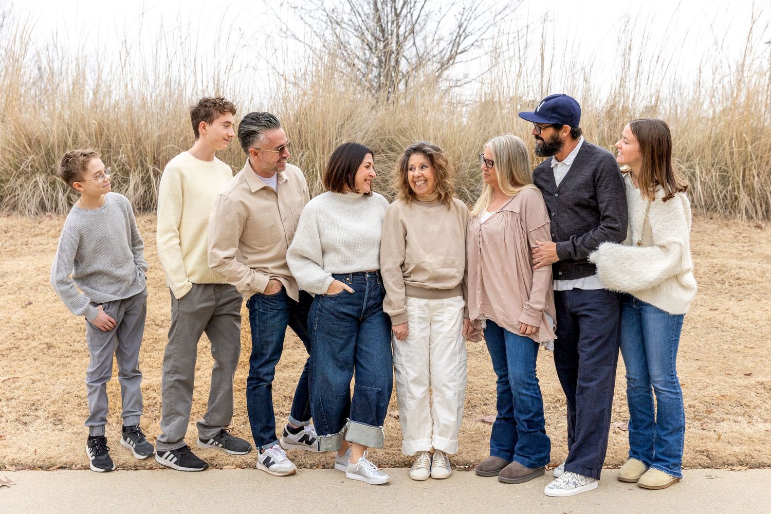 Family lying together on wooden bridge during outdoor photo session.