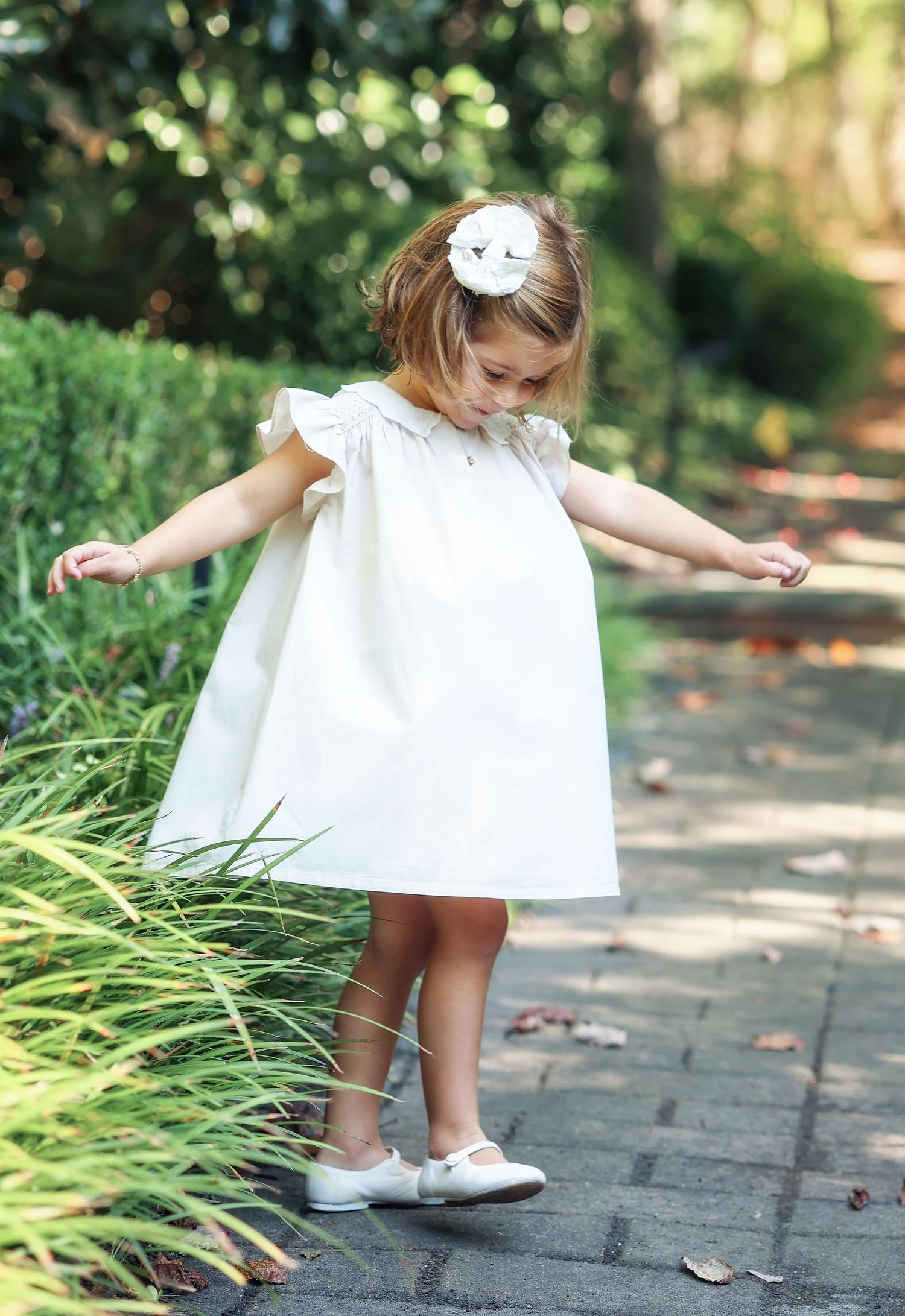 little girl in pretty dress spinning and watching her dress spin along