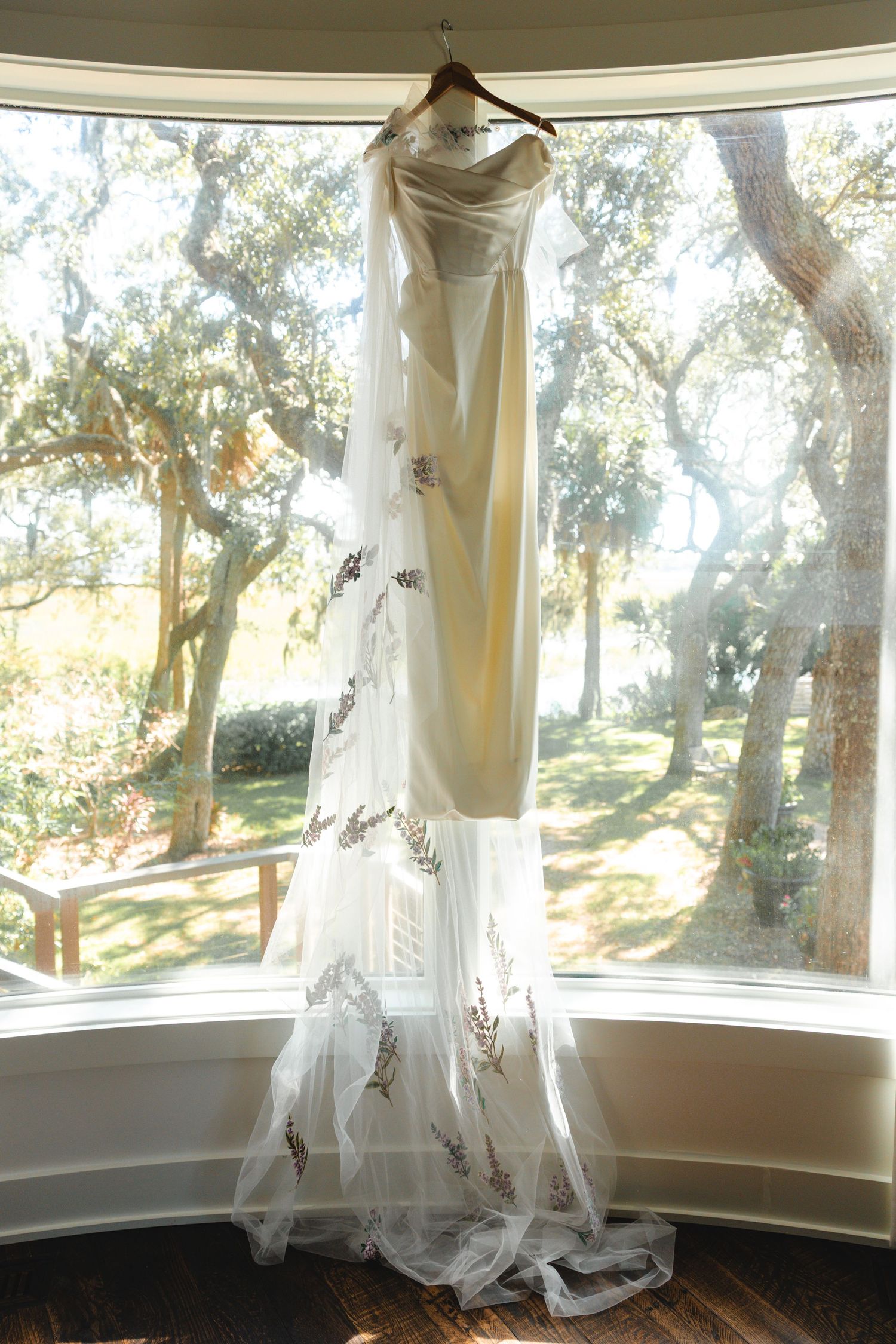 Sheer white curtains hang elegantly in a curved bay window with natural light streaming through.