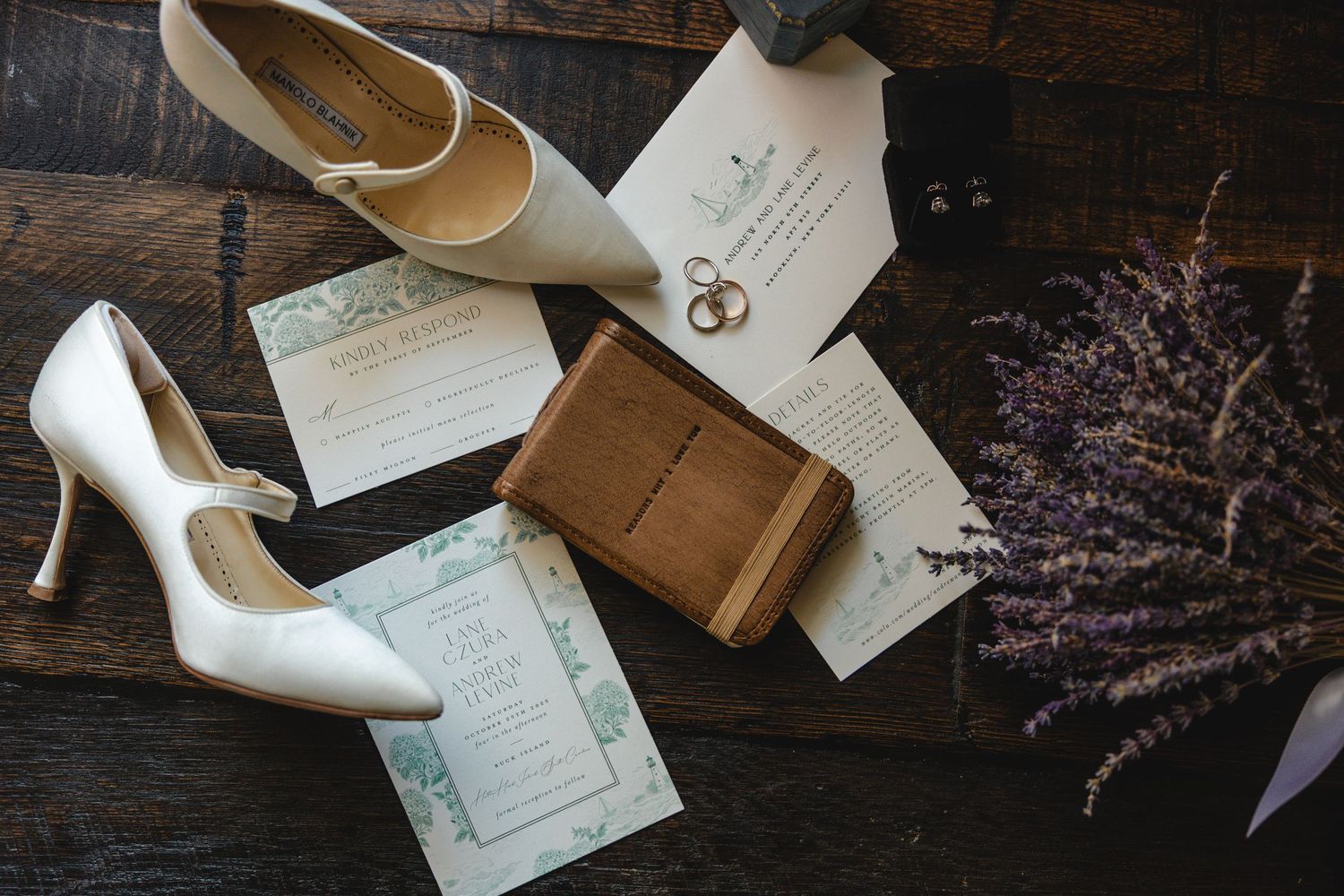 Wedding invitation suite with heels, dried lavender, and vintage-inspired stationery on dark wooden surface.