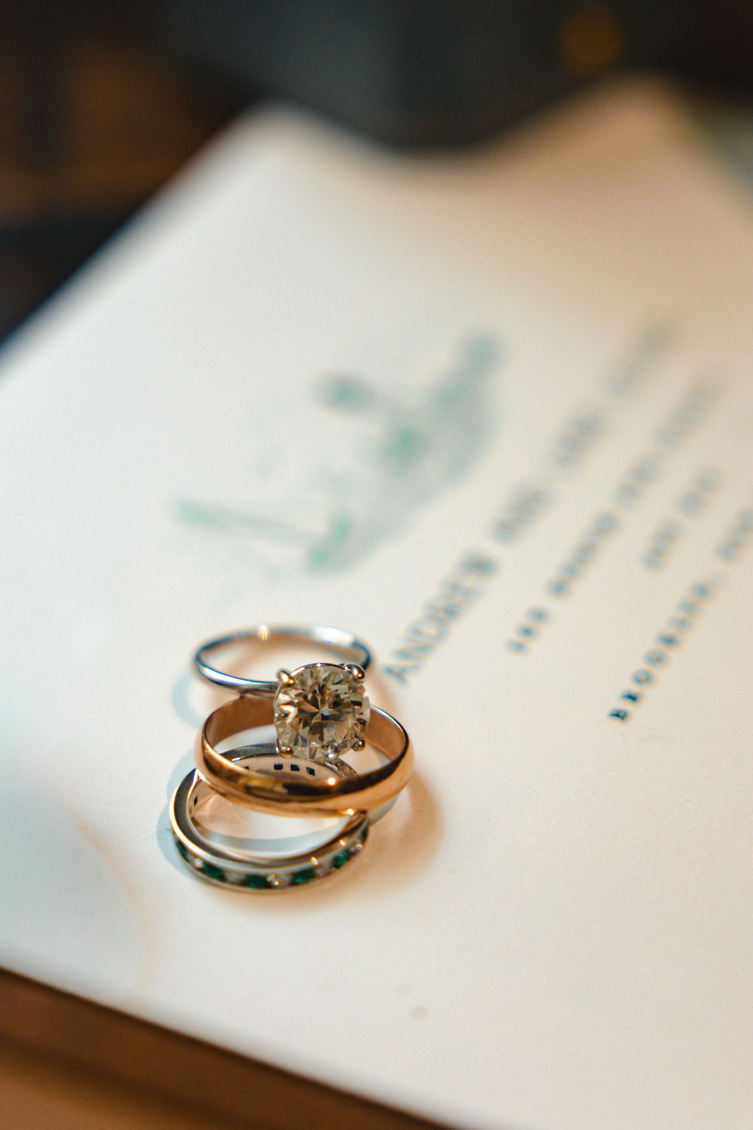 Wedding rings photographed on white paper with shallow depth of field.