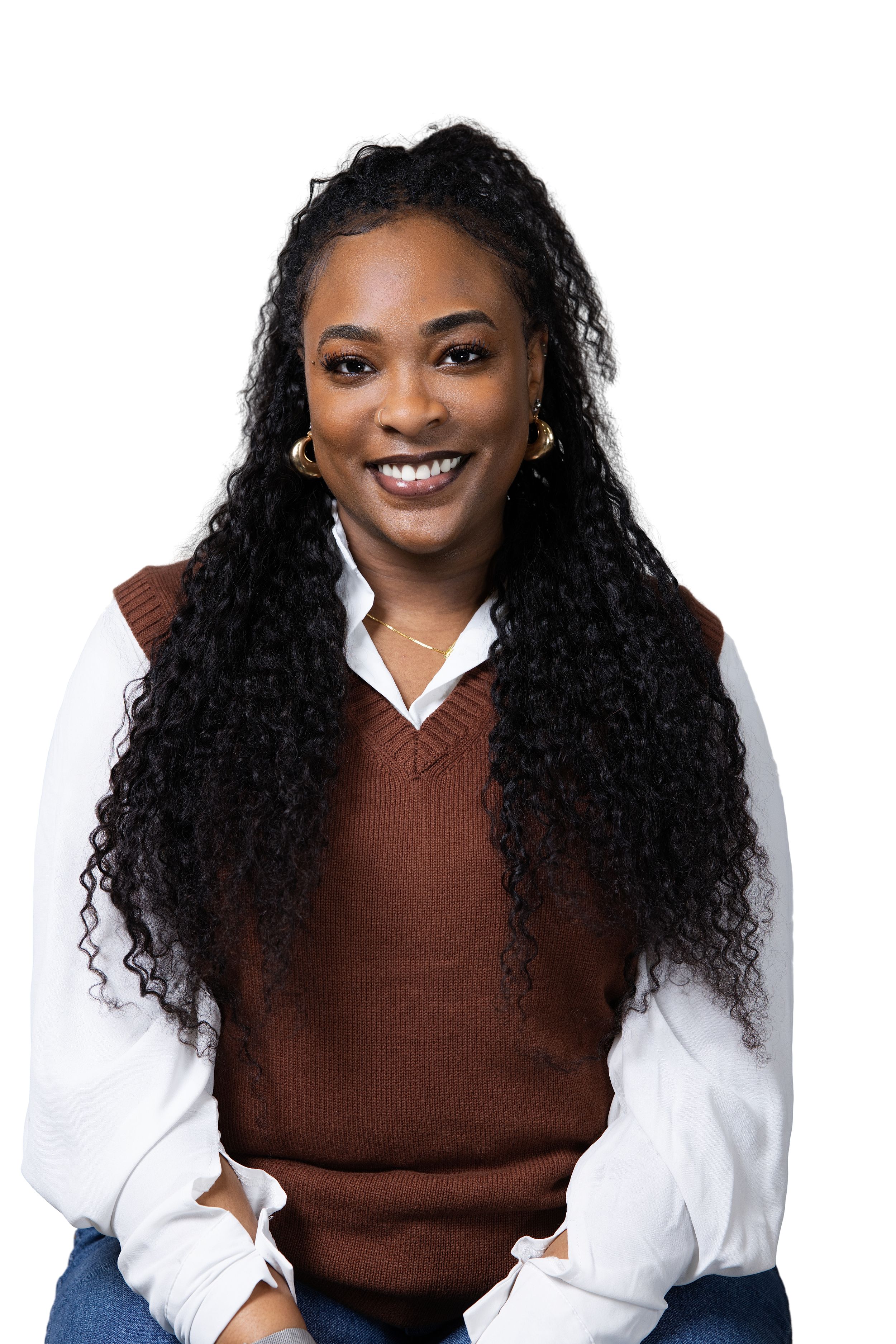 Professional studio portrait with brown sweater vest and white button-down shirt against light background.