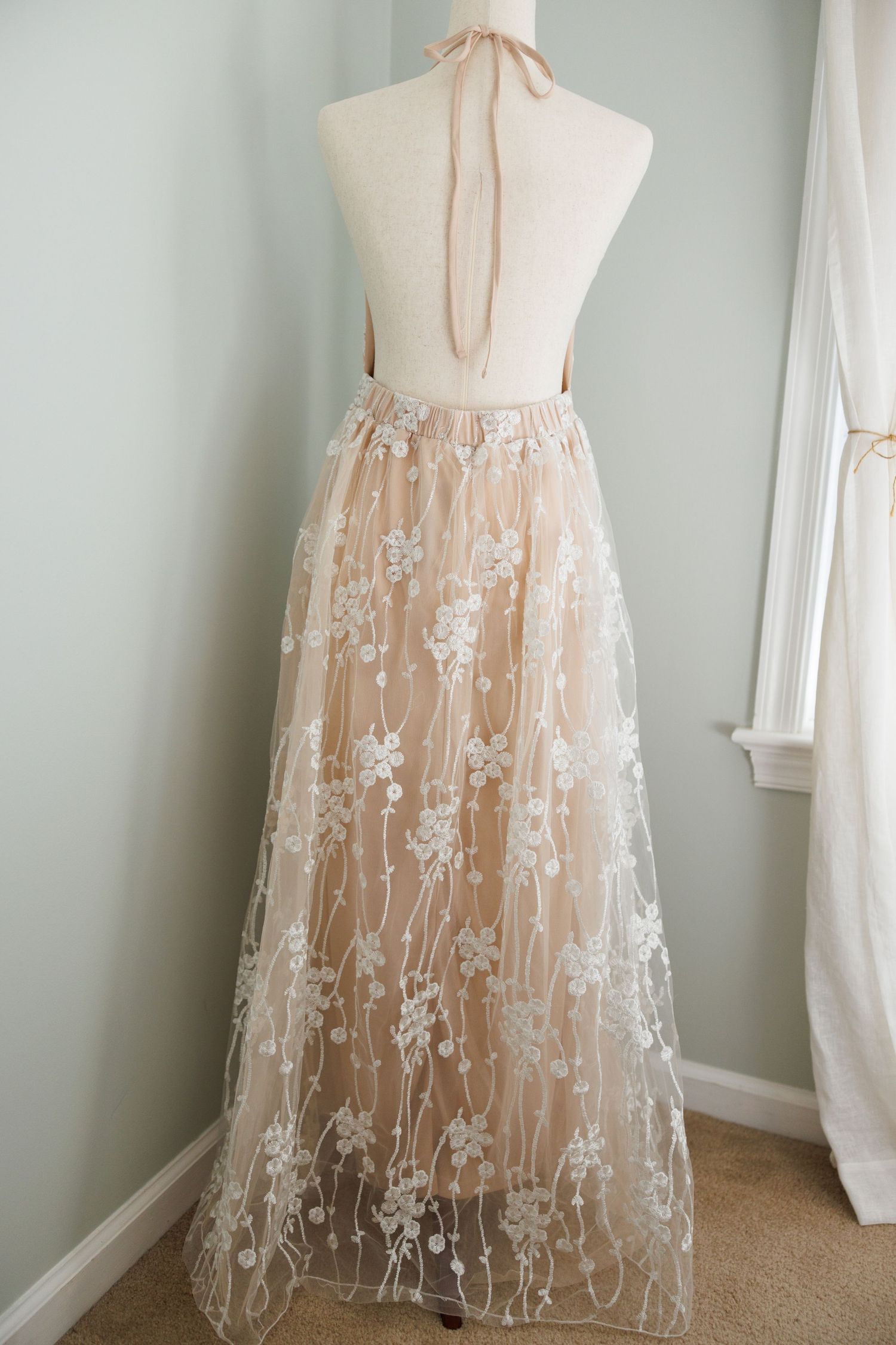 Vintage cream-colored peasant dress with puff sleeves and corset back lacing displayed on mannequin from multiple angles.