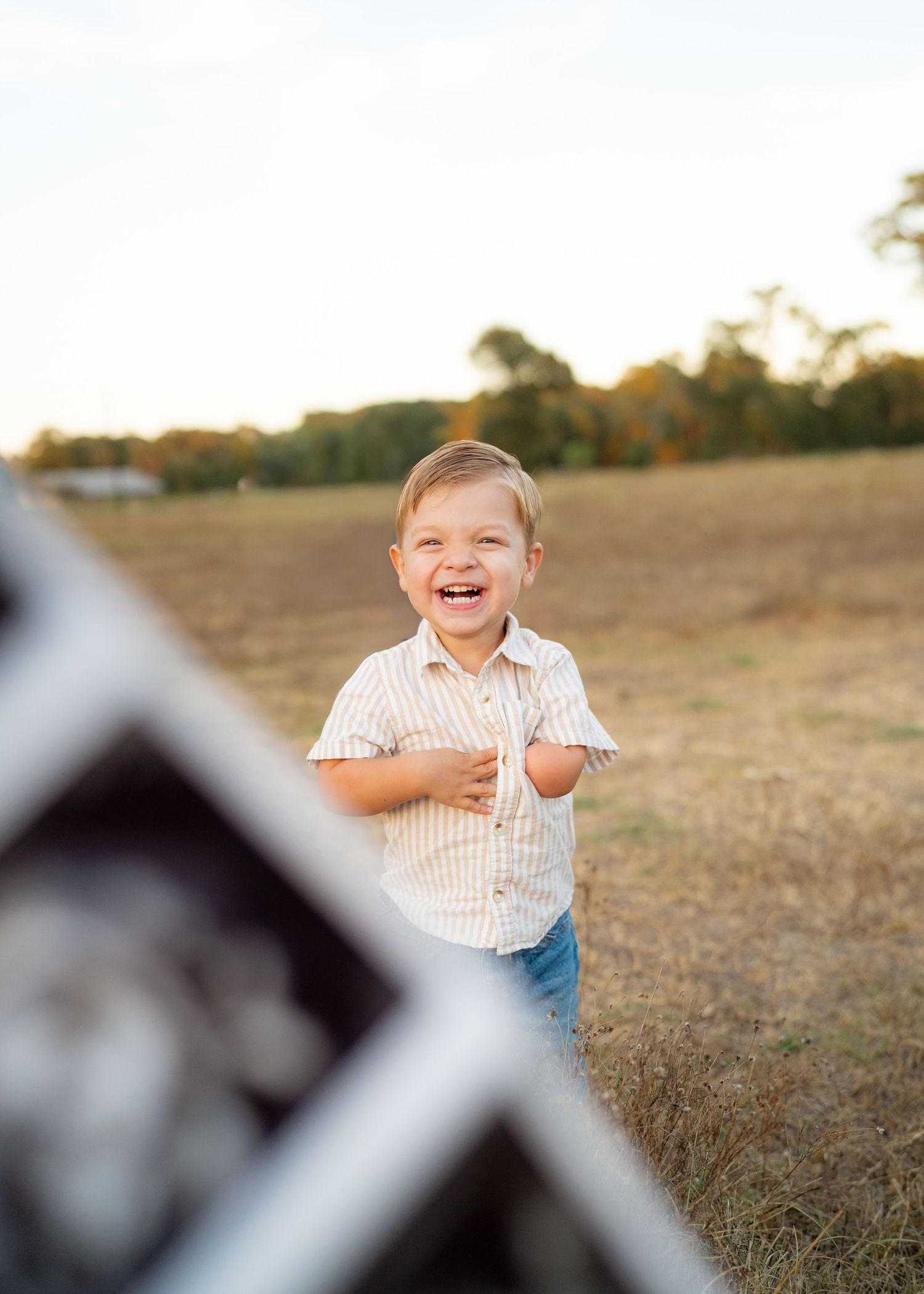 Toddler playing peekaboo with ultrasound image during baby announcement photoshoot.