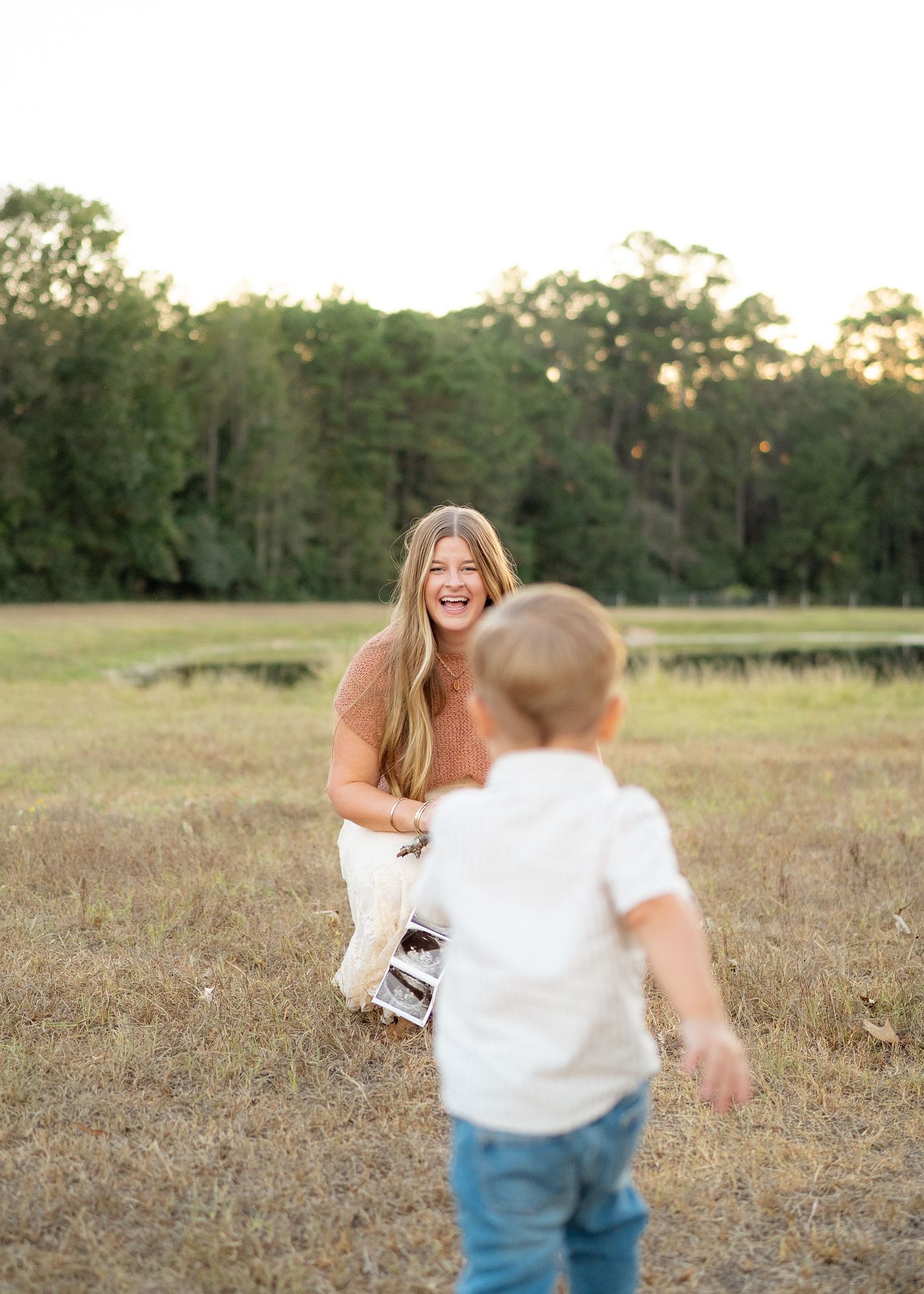 Energetic toddler running toward mom during a playful family photo session.