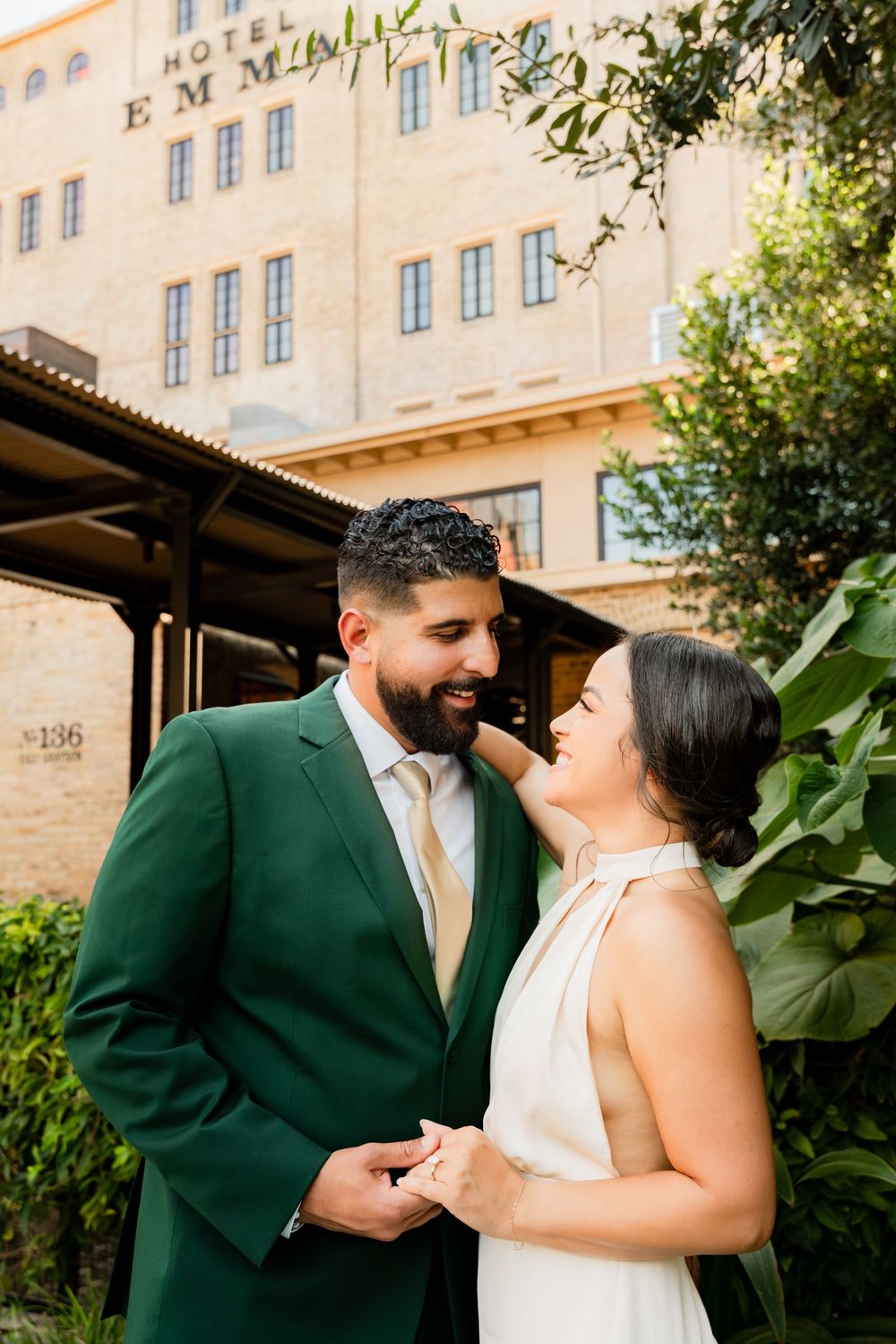 A couple shares a joyful moment together outside the historic Hotel Emma building in San Antonio.