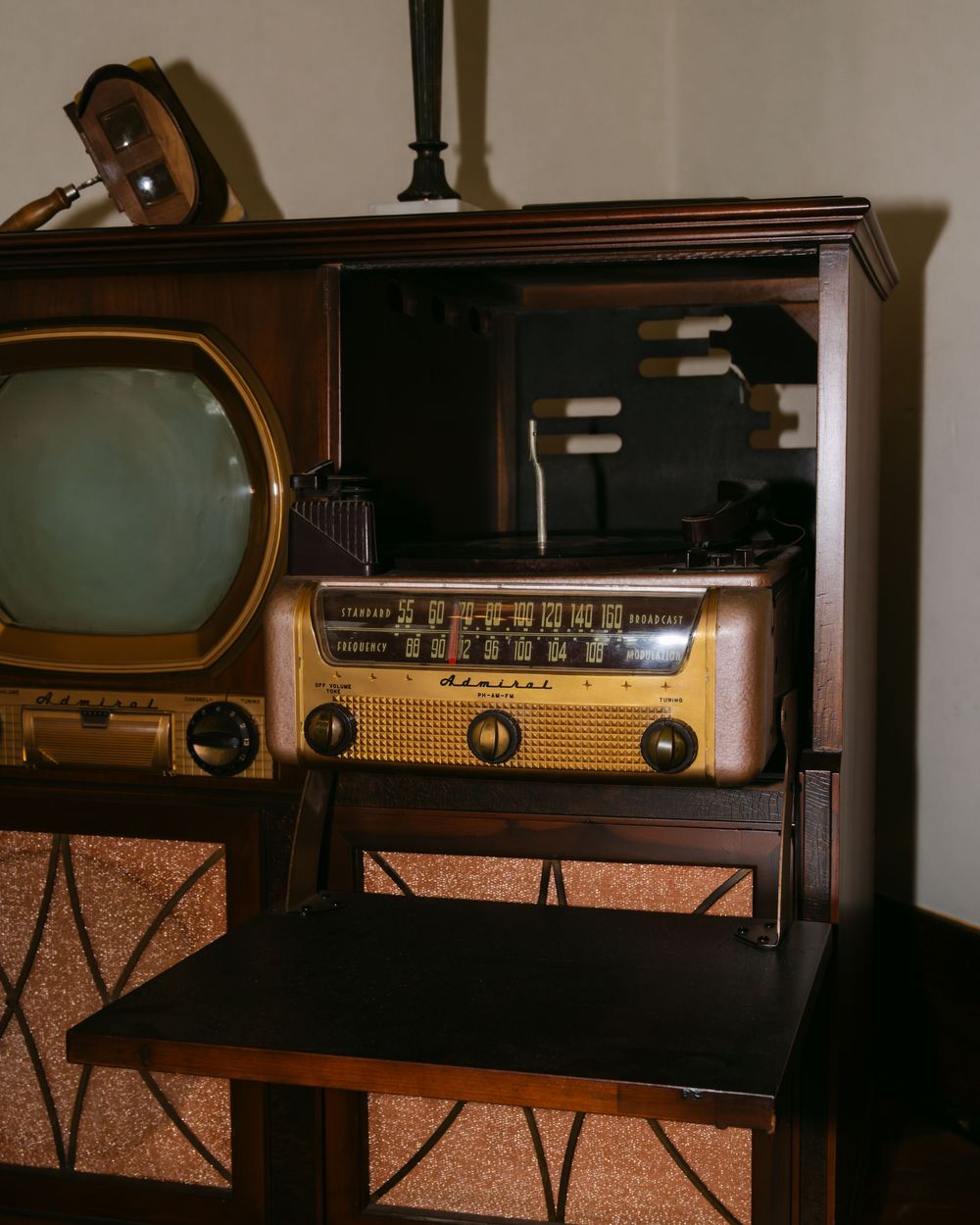 Vintage wooden radio sets displayed on a dark wooden surface.