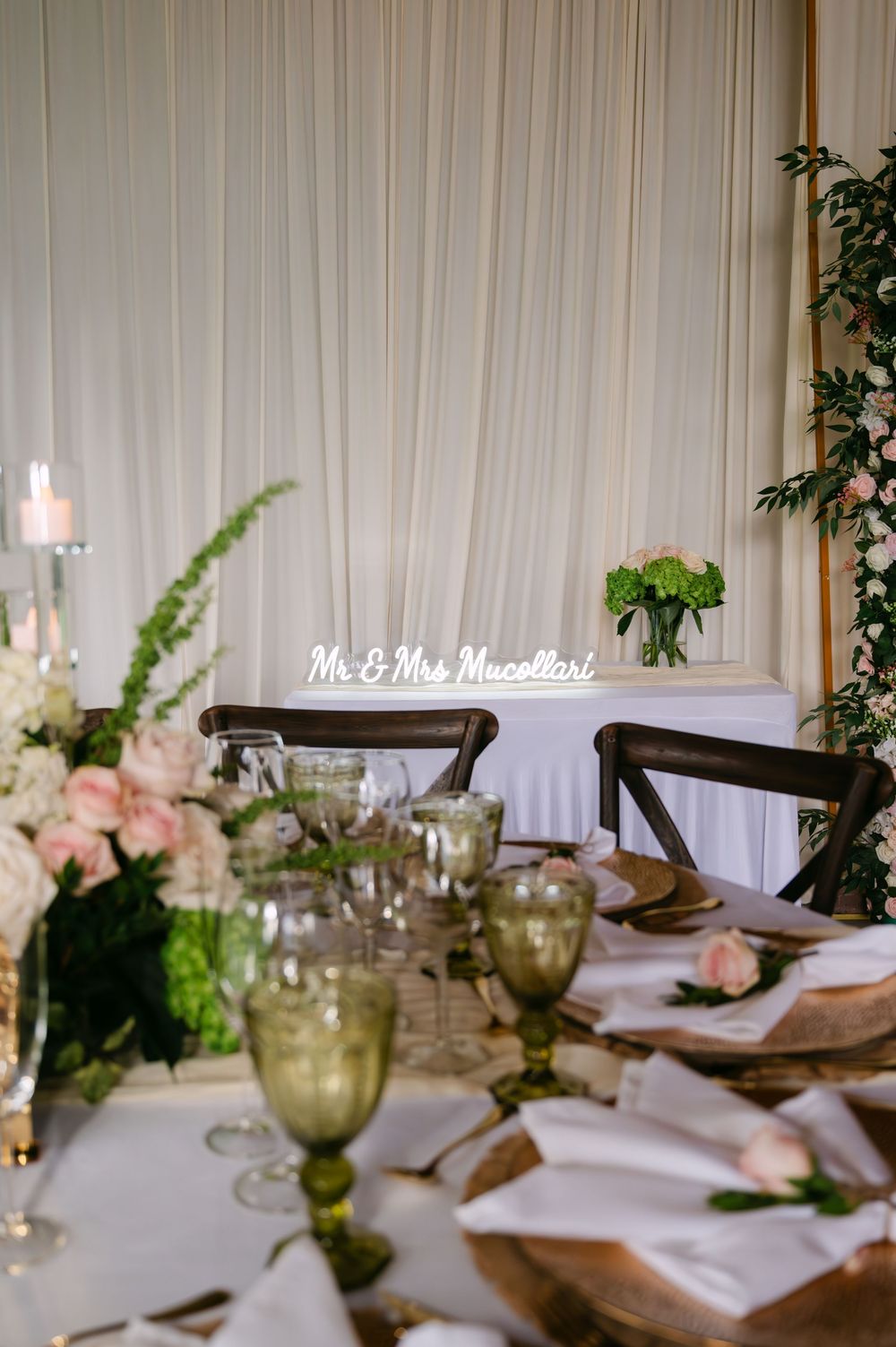 Elegant wedding reception table settings with white linens and floral centerpieces.