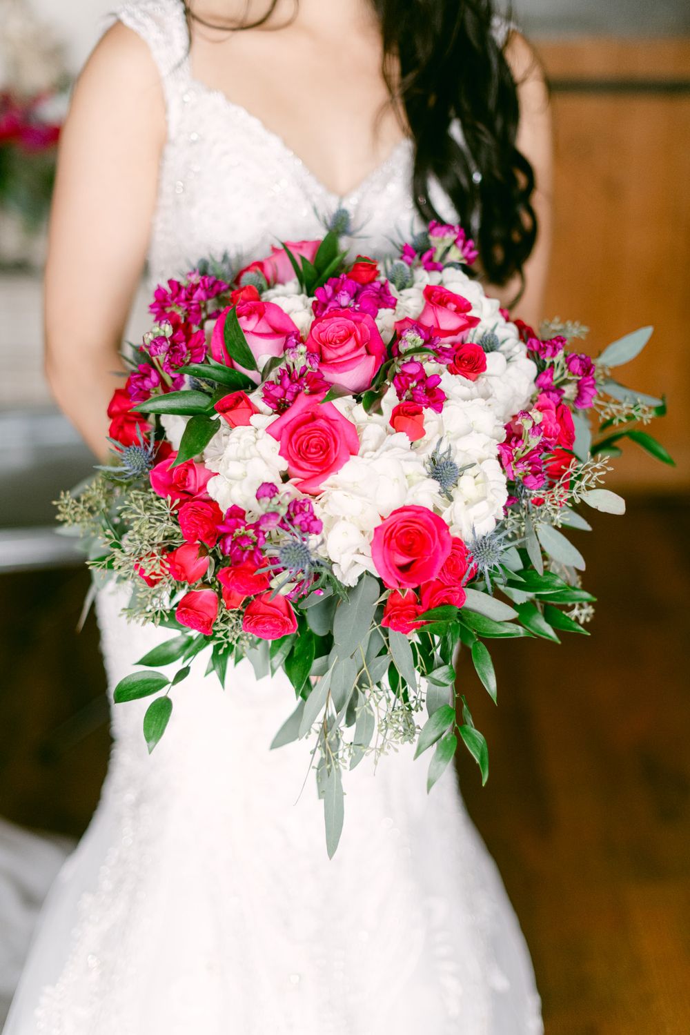 A stunning pink and white bridal bouquet with roses and eucalyptus leaves creates an elegant wedding arrangement.