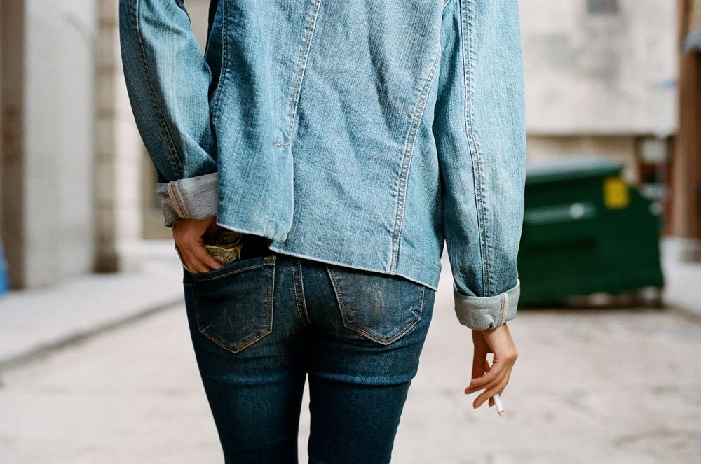 Person wearing blue denim jacket shown from behind.