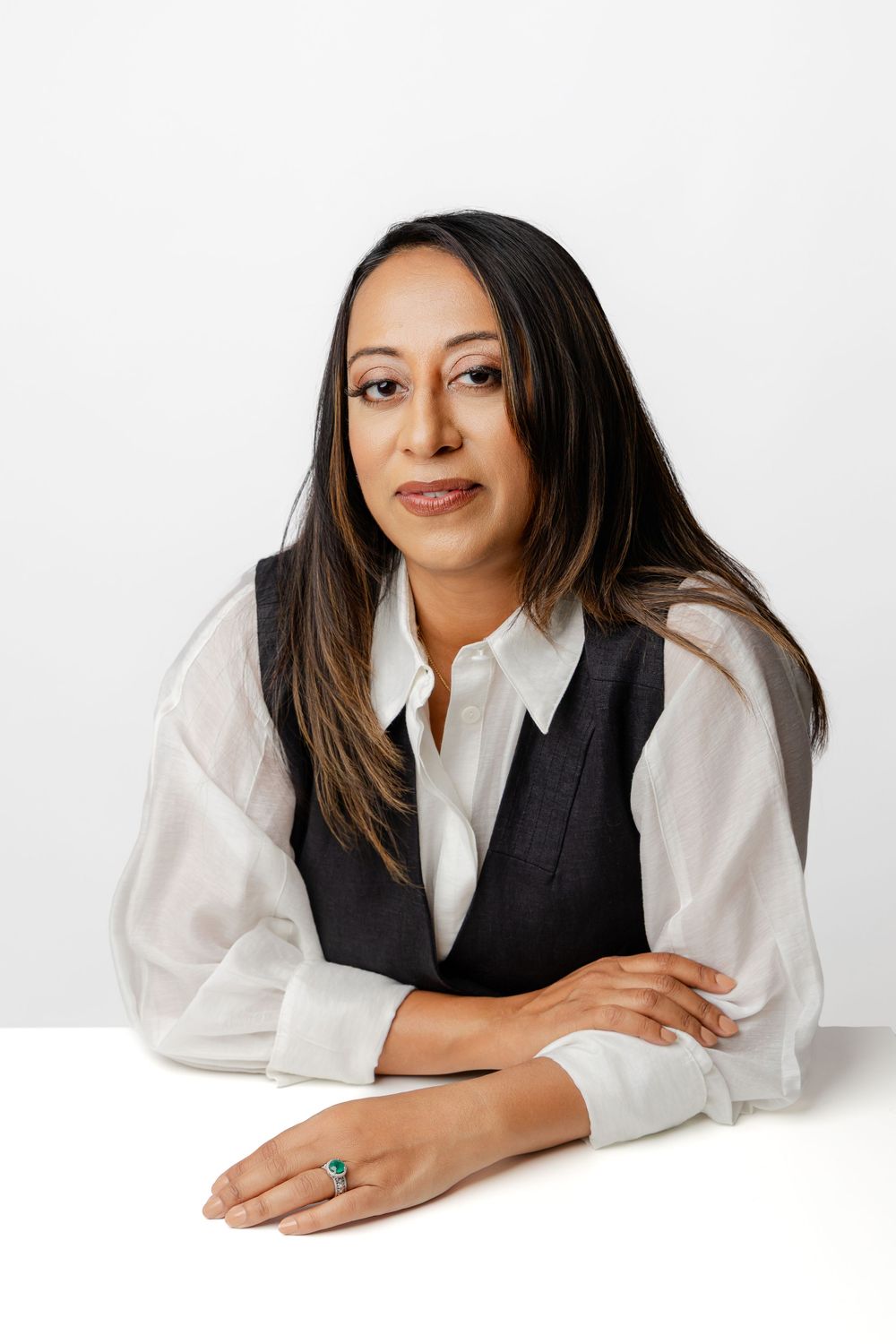 Professional studio portraits showing a person in business attire lying on white backdrop in various relaxed poses.