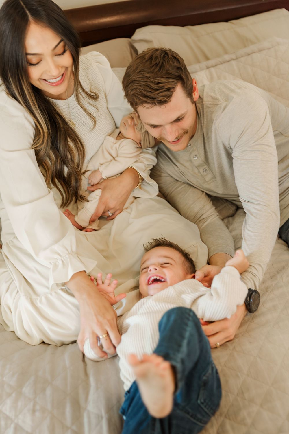 Family sharing joyful moments and laughter while relaxing together on a bed.