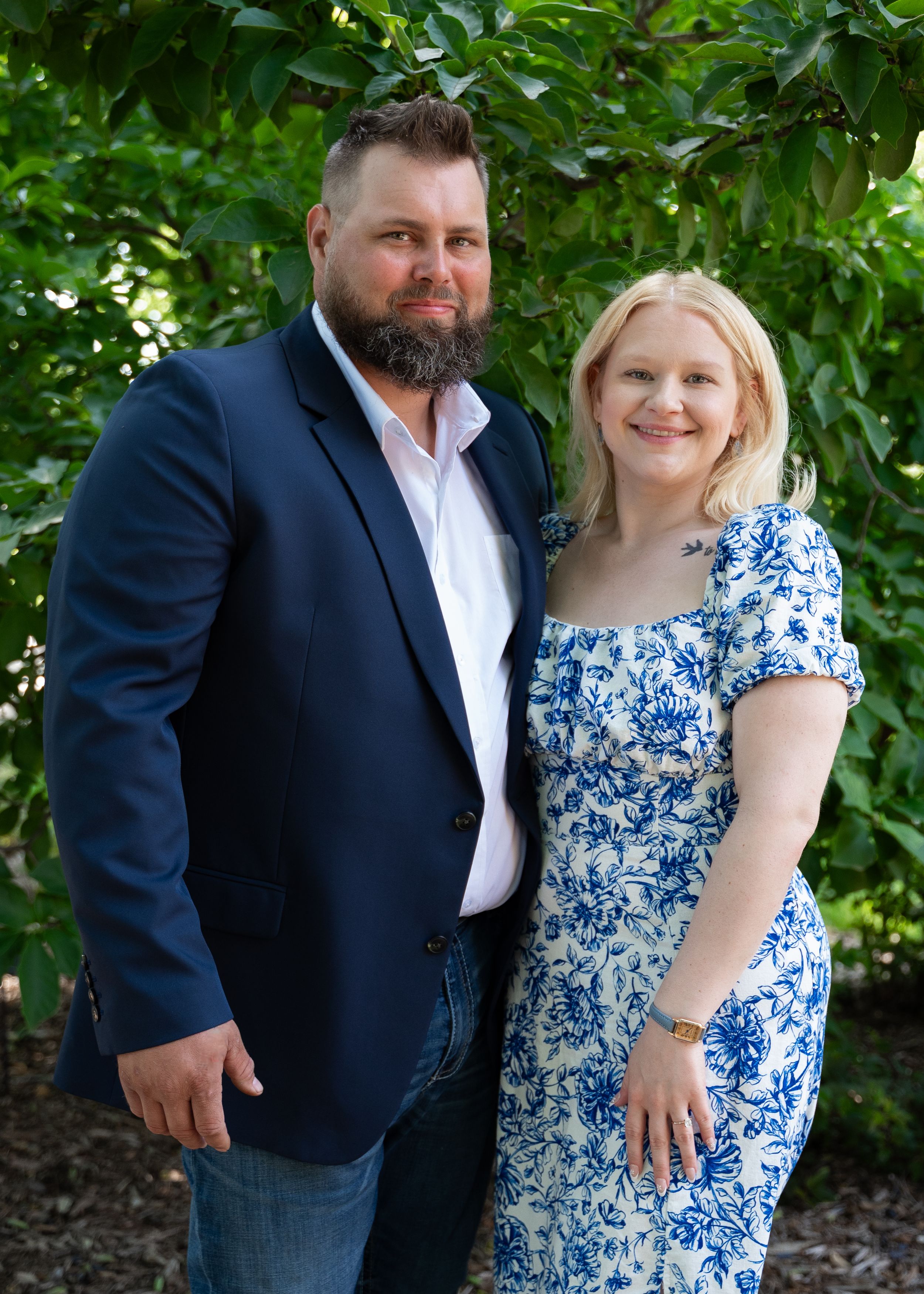 Couple standing side by side with powell garden behind them