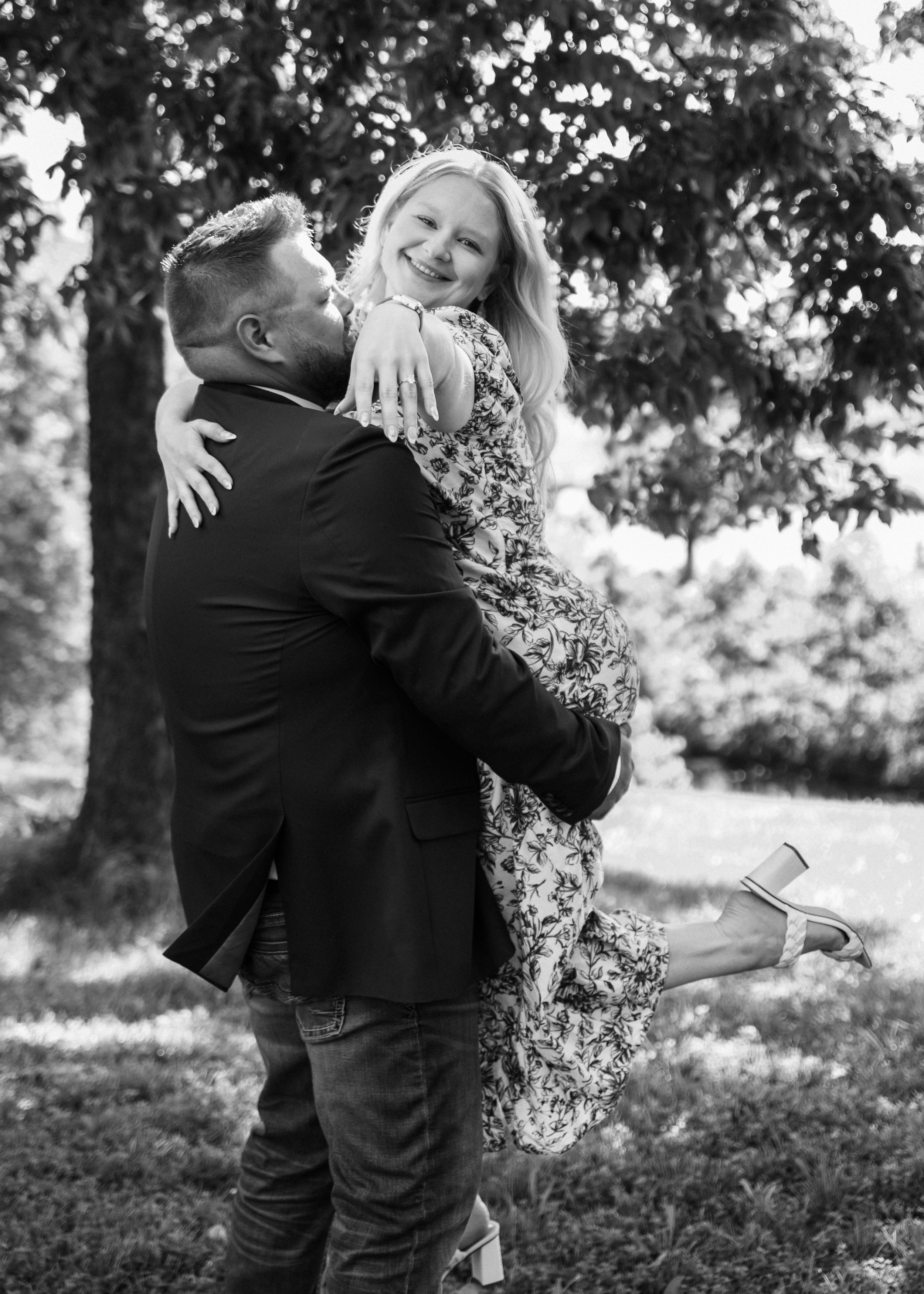 A romantic black and white photo series showing a couple embracing on a wooded path.