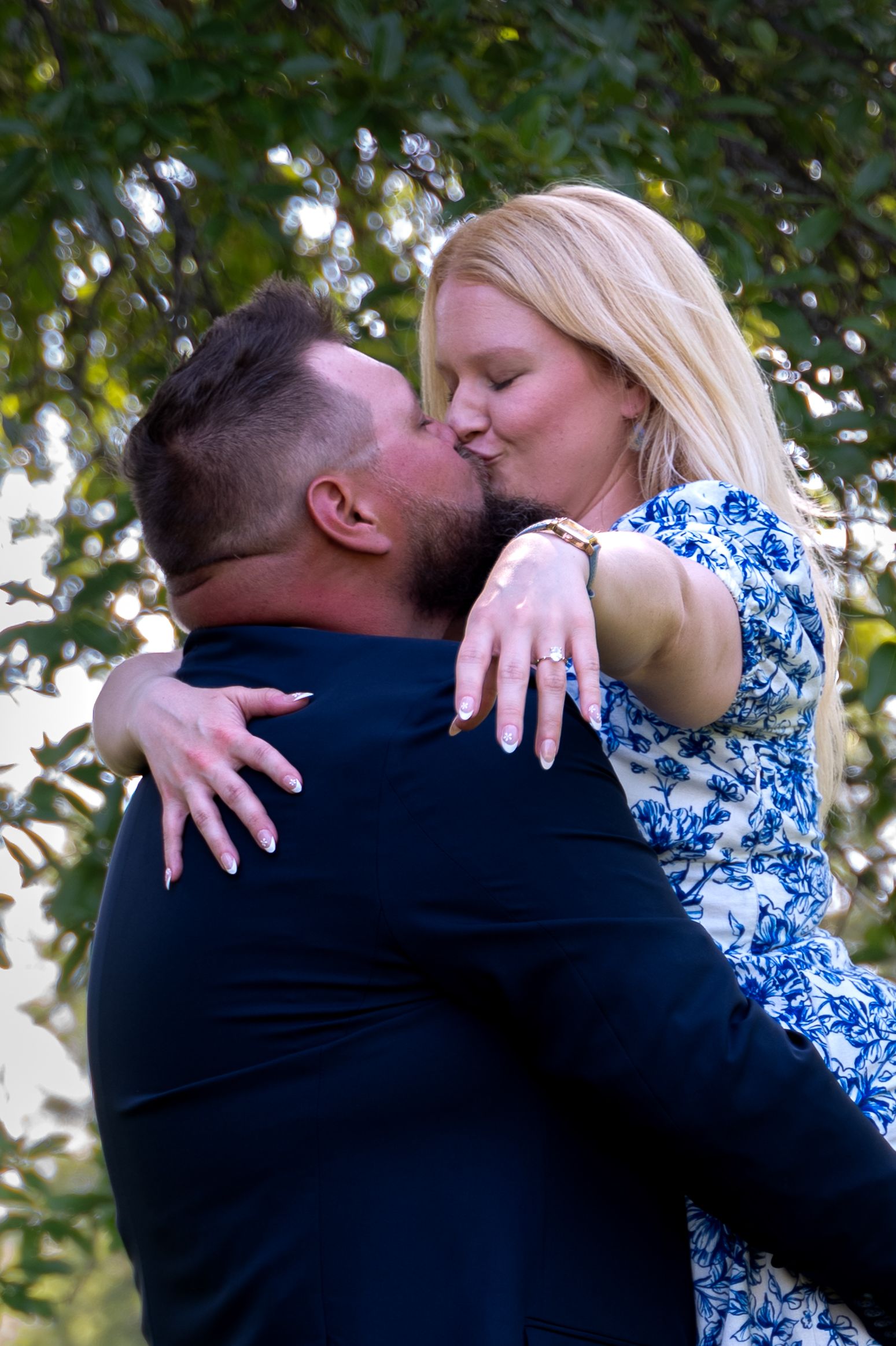 A series of intimate moments captured between a couple in a blue floral dress and dark suit.