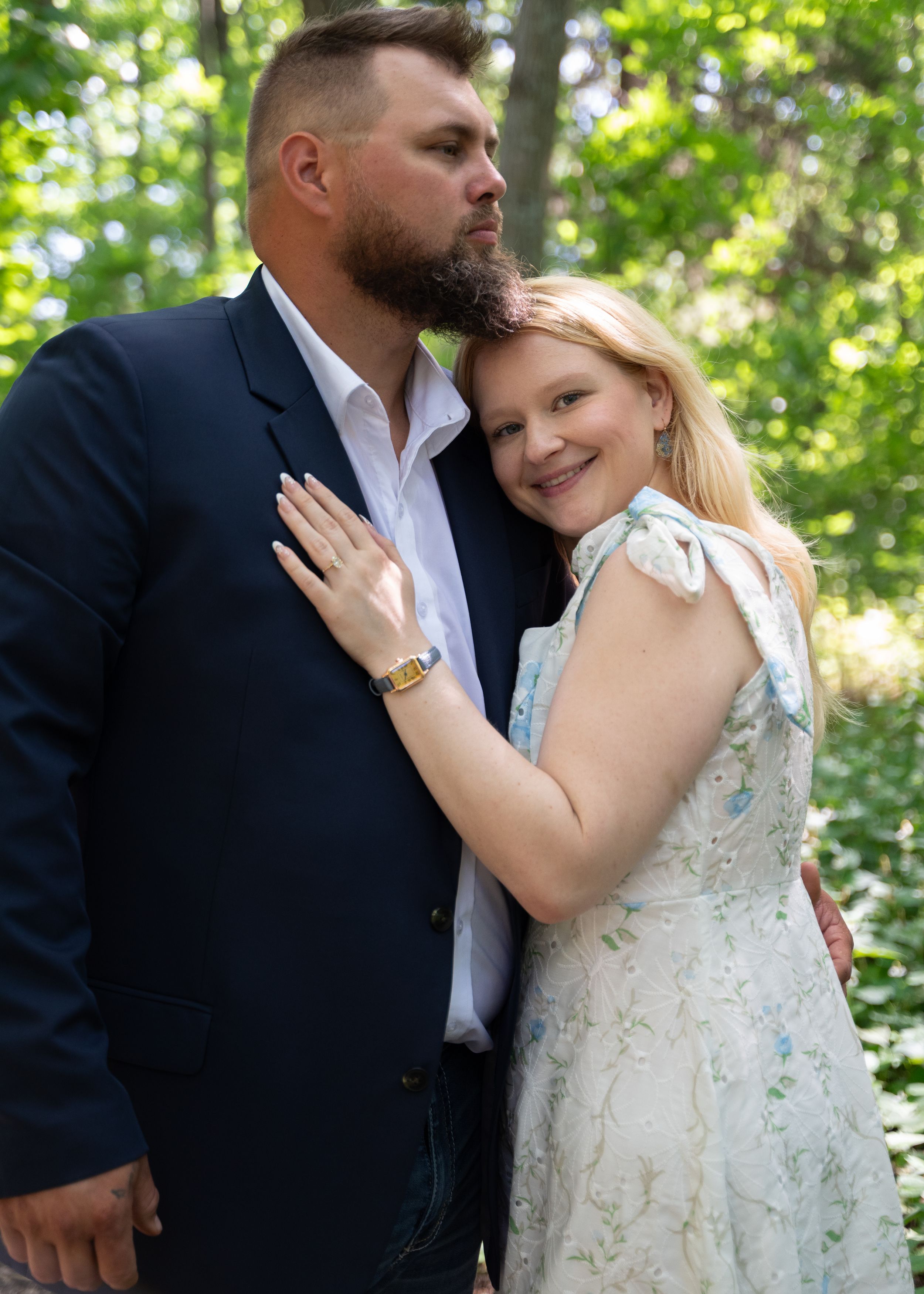 A romantic couple's photoshoot in a lush green forest setting.