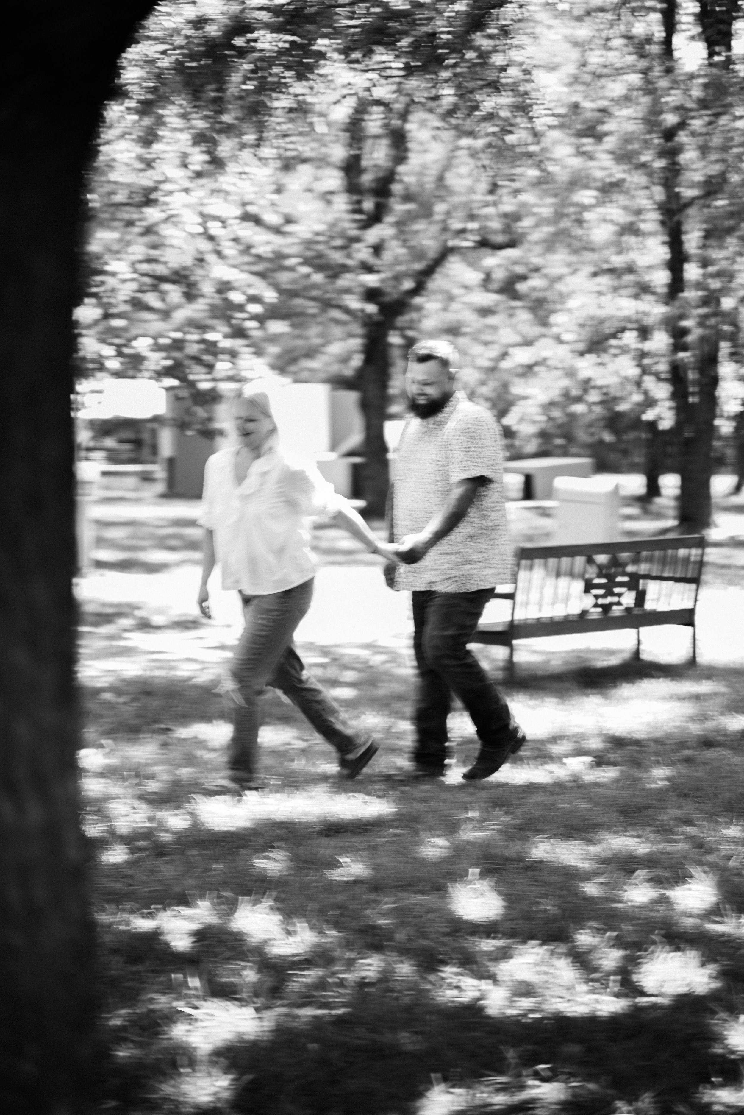 Black and white sequence of two people dancing in a sunlit park.