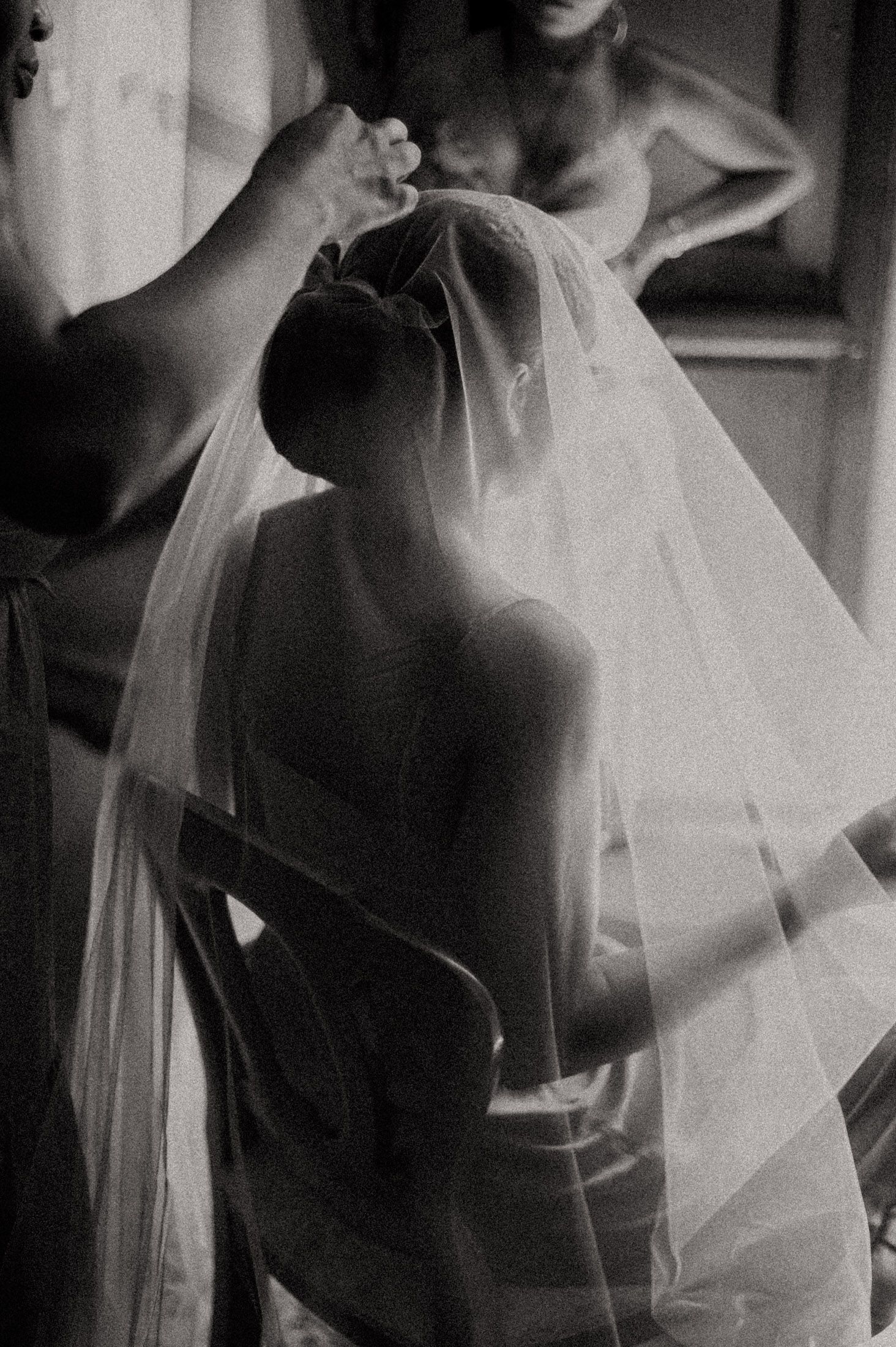 A series of black and white photos showing delicate bridal veil fabric draping and flowing in soft light.