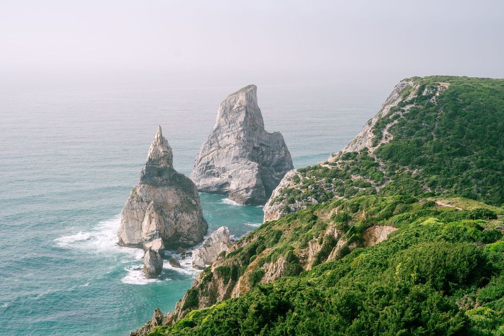 Dramatic coastal rock formations and cliffs rising from turquoise ocean waters.