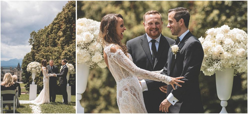 A couple joyfully embraces during their outdoor wedding ceremony surrounded by blooming flowers.