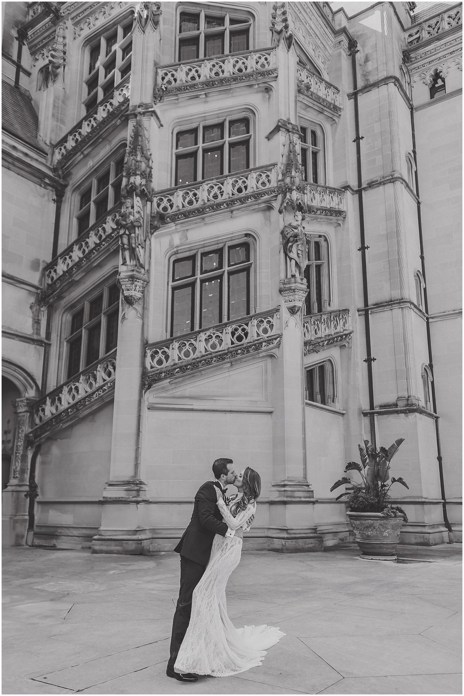A romantic wedding couple shares intimate moments against the backdrop of an ornate stone building architecture.