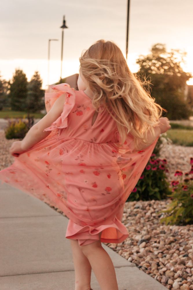 Joyful child spinning in pink floral dress capturing pure childhood happiness, Westminster family photographer