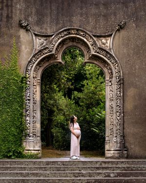 Sessão fotográfica de grávida no jardim, com pórtico muito bonito e antigo.