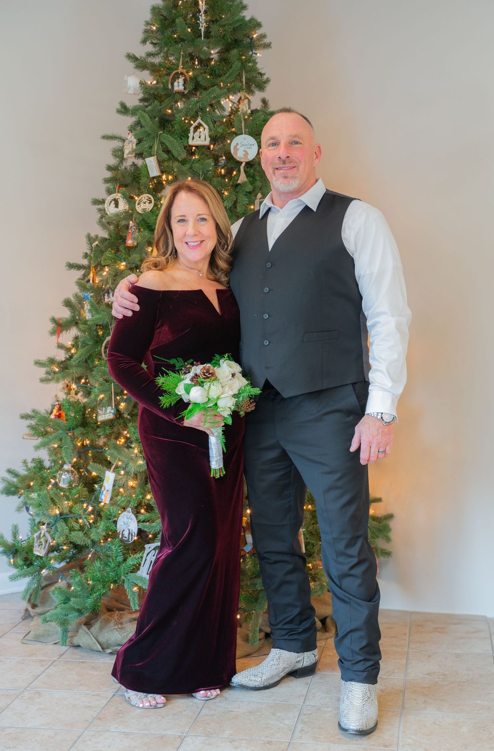 Couple in formal attire poses for progressive dance sequence in front of decorated Christmas tree.