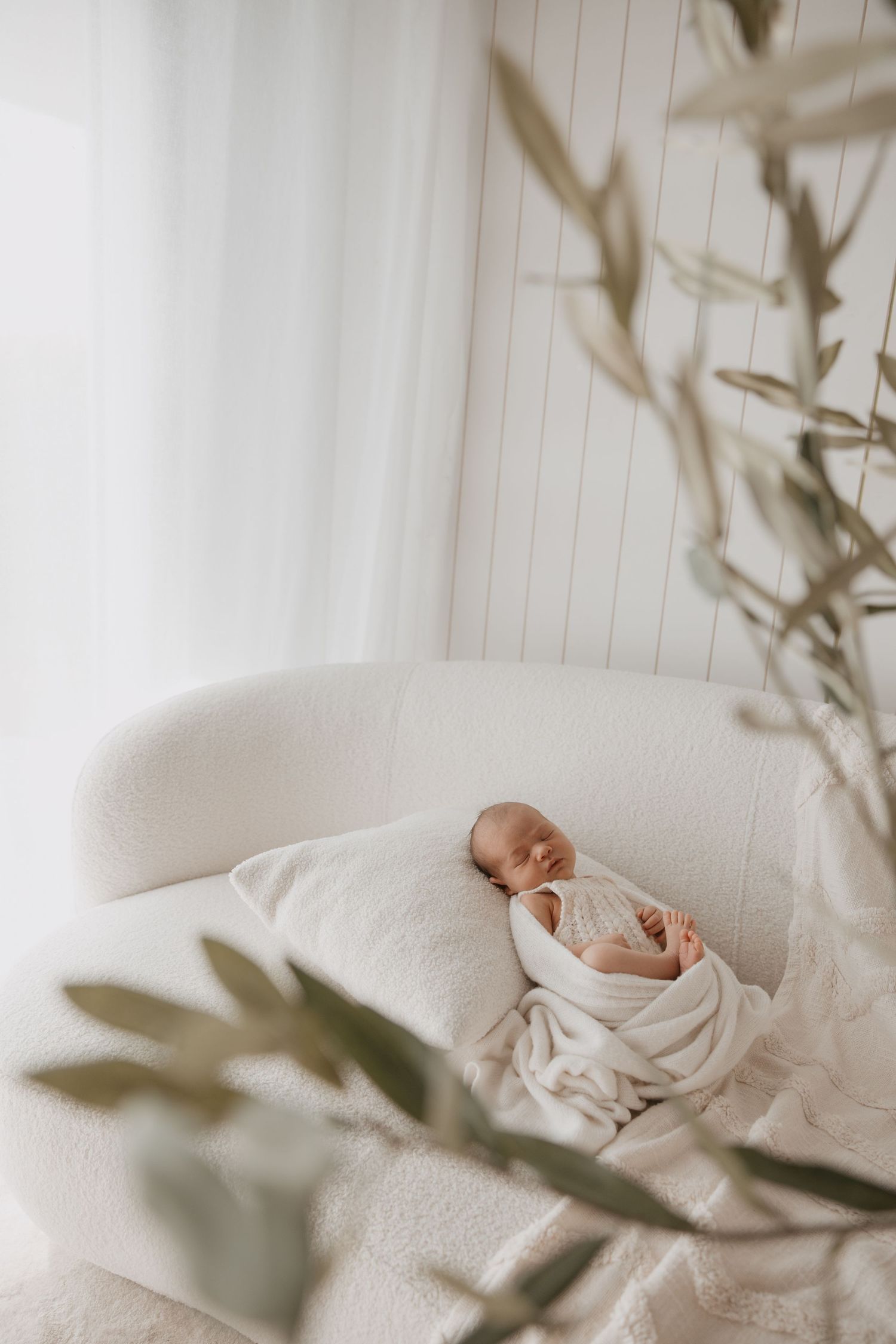 Intimate lifestyle photography session on white bedding with neutral tones.