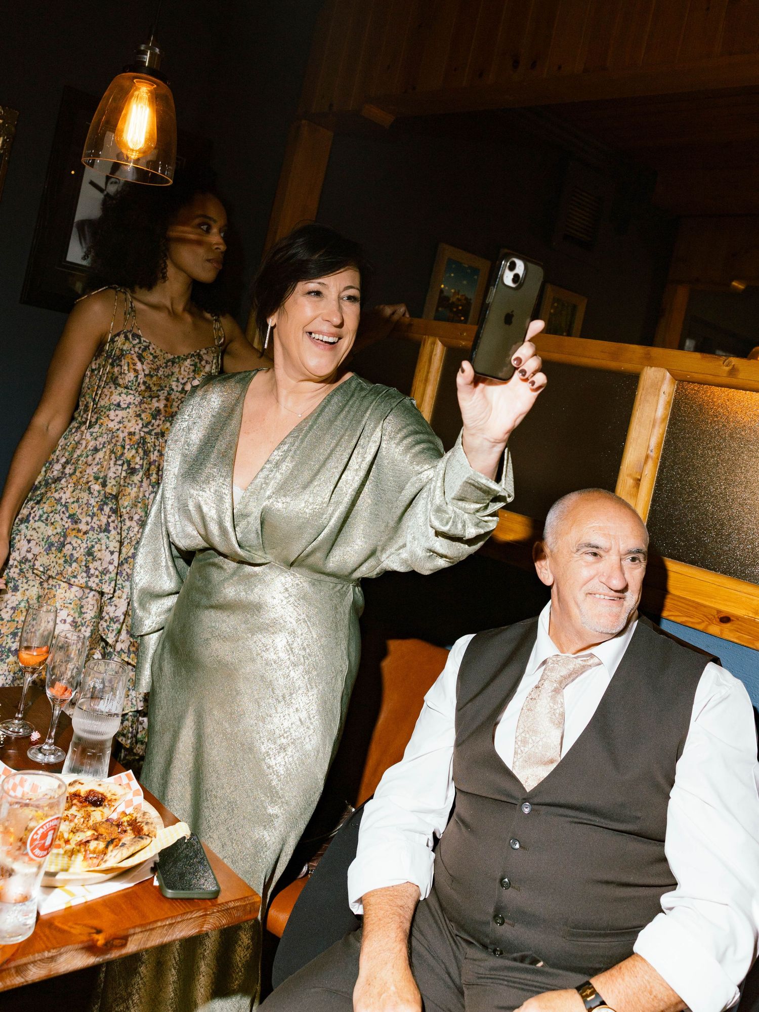 People enjoying a celebration at a rustic restaurant with warm lighting and festive atmosphere.
